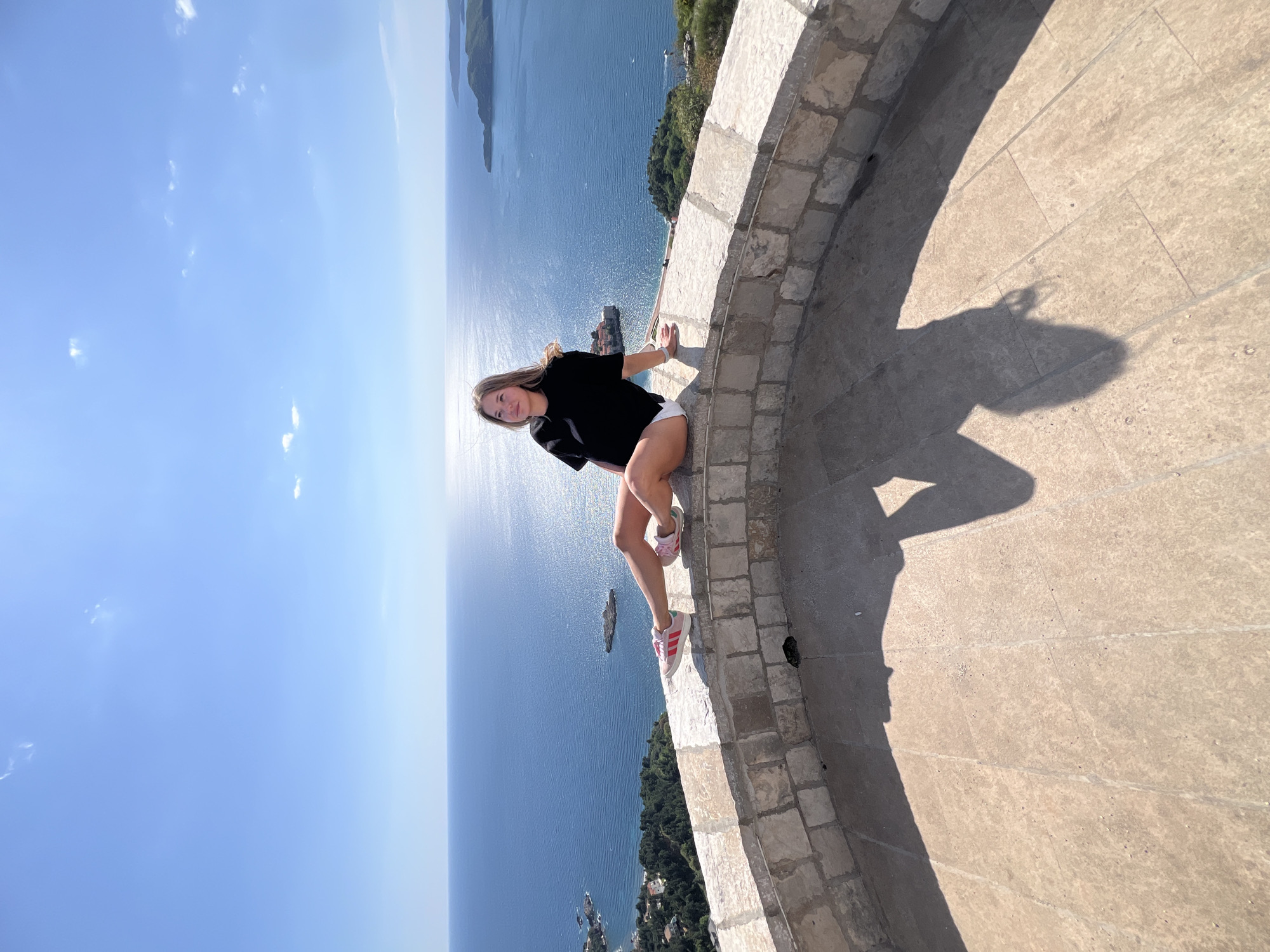 Tourists photograph scenic Adriatic views at Montenegro's Sveti Stefan