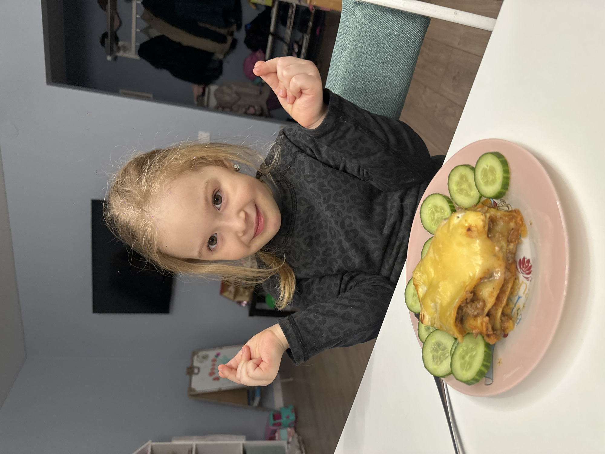 Girl eats meal near pink artwork in Chaikovsky home