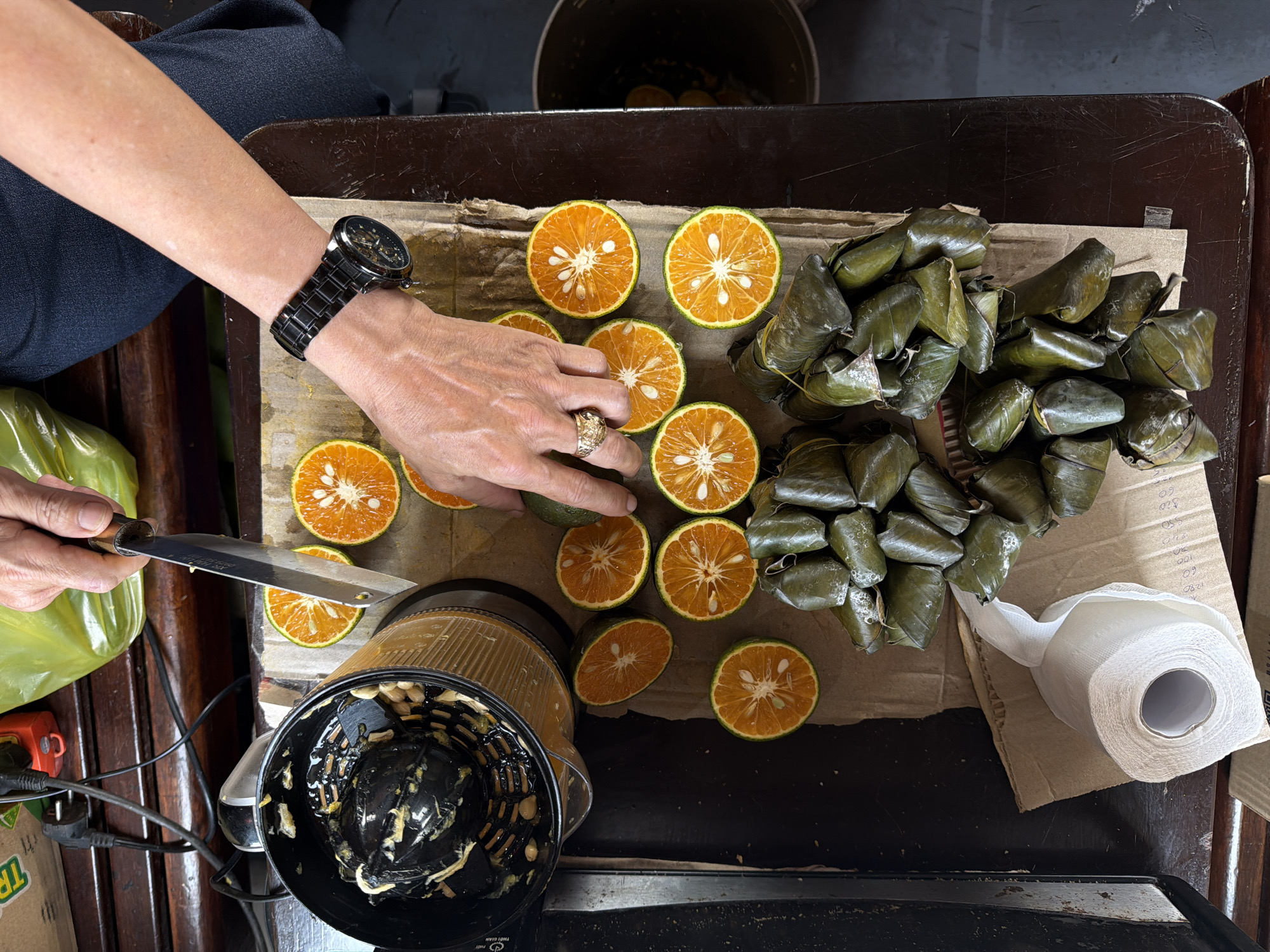 Person prepares citrus fruit in domestic setting, Huế