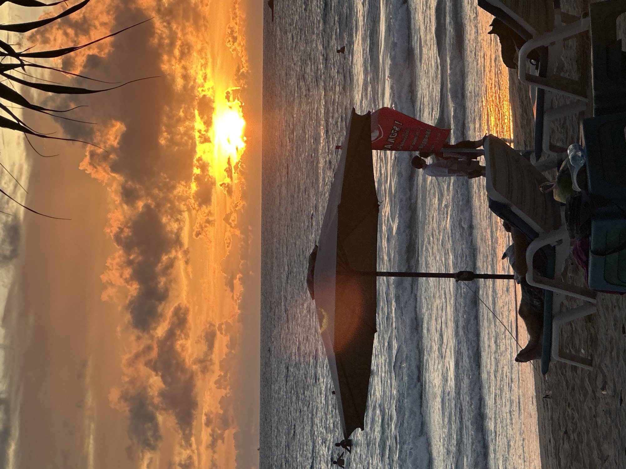 Karon Beach sunset with parasailing, boats, and beachgoers