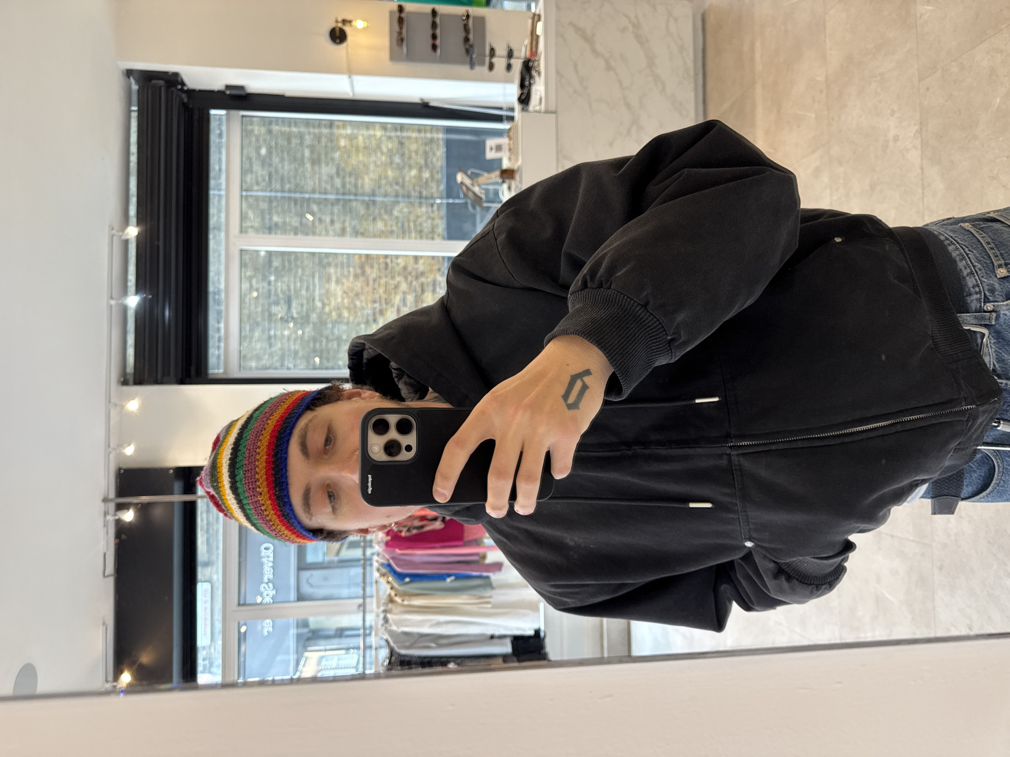 Person takes mirror selfie in London clothing store