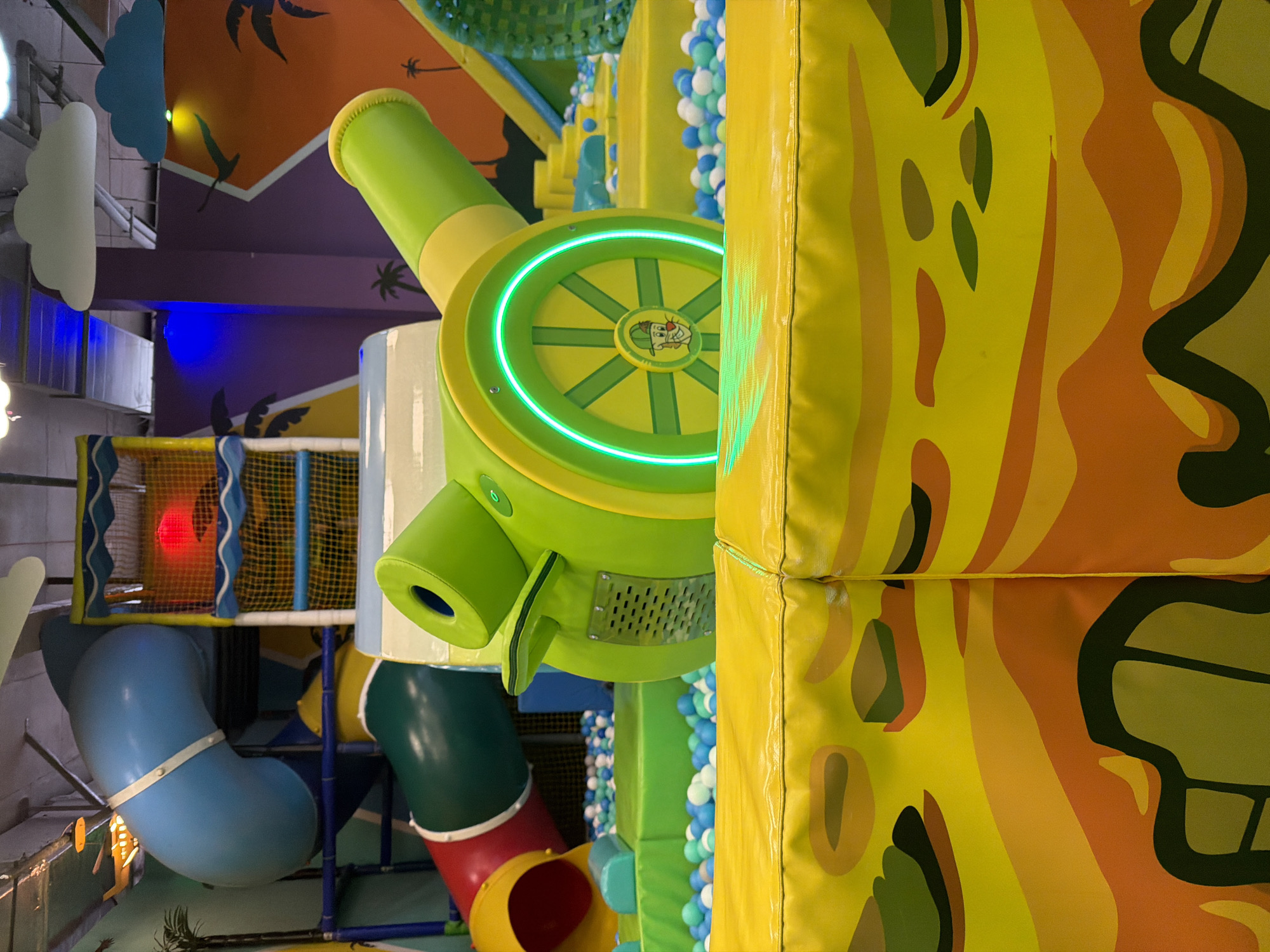 Child enjoys indoor playground with trampolines and inflatable attractions