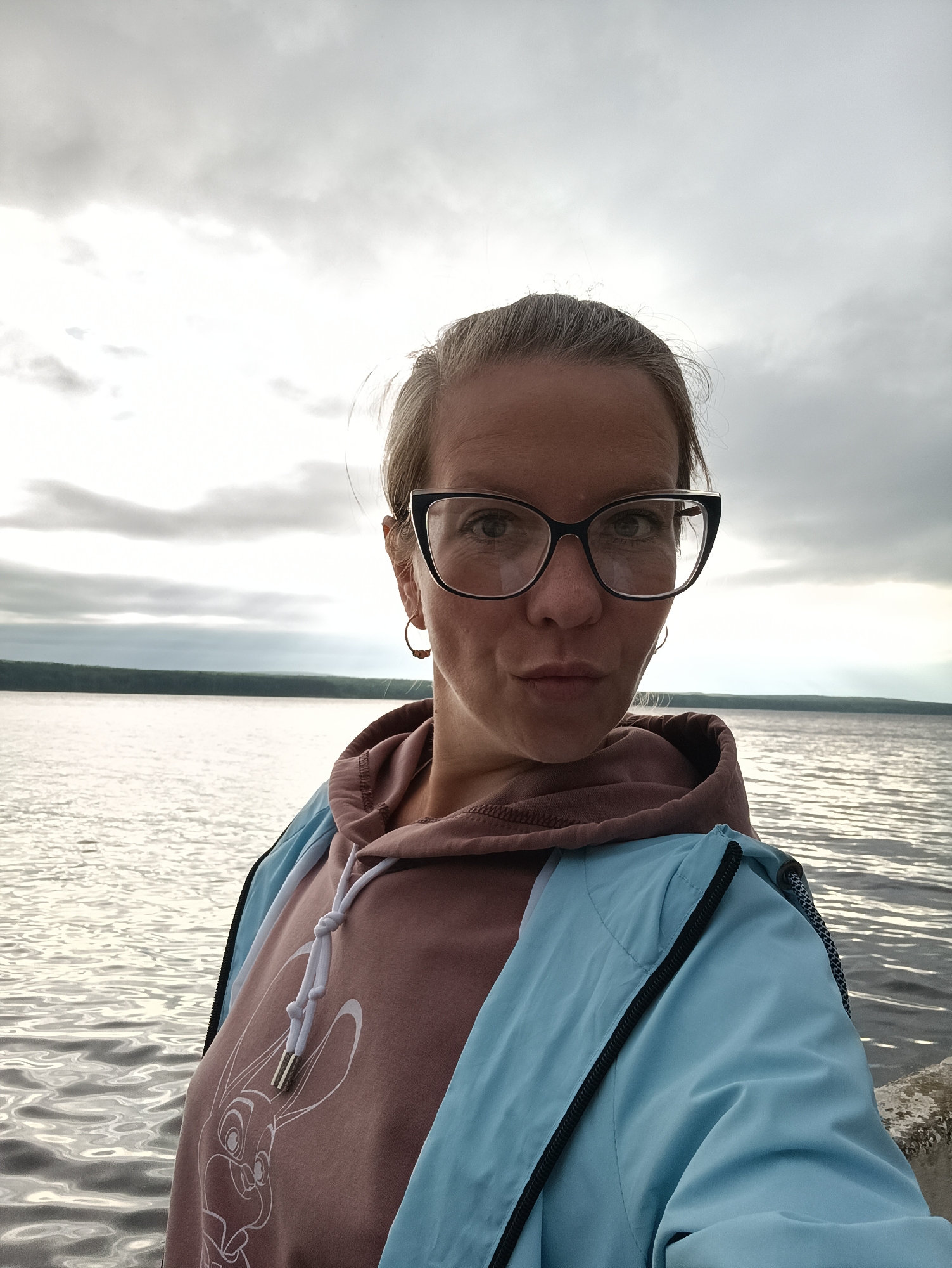 Woman takes early morning selfies by water in Chaikovsky