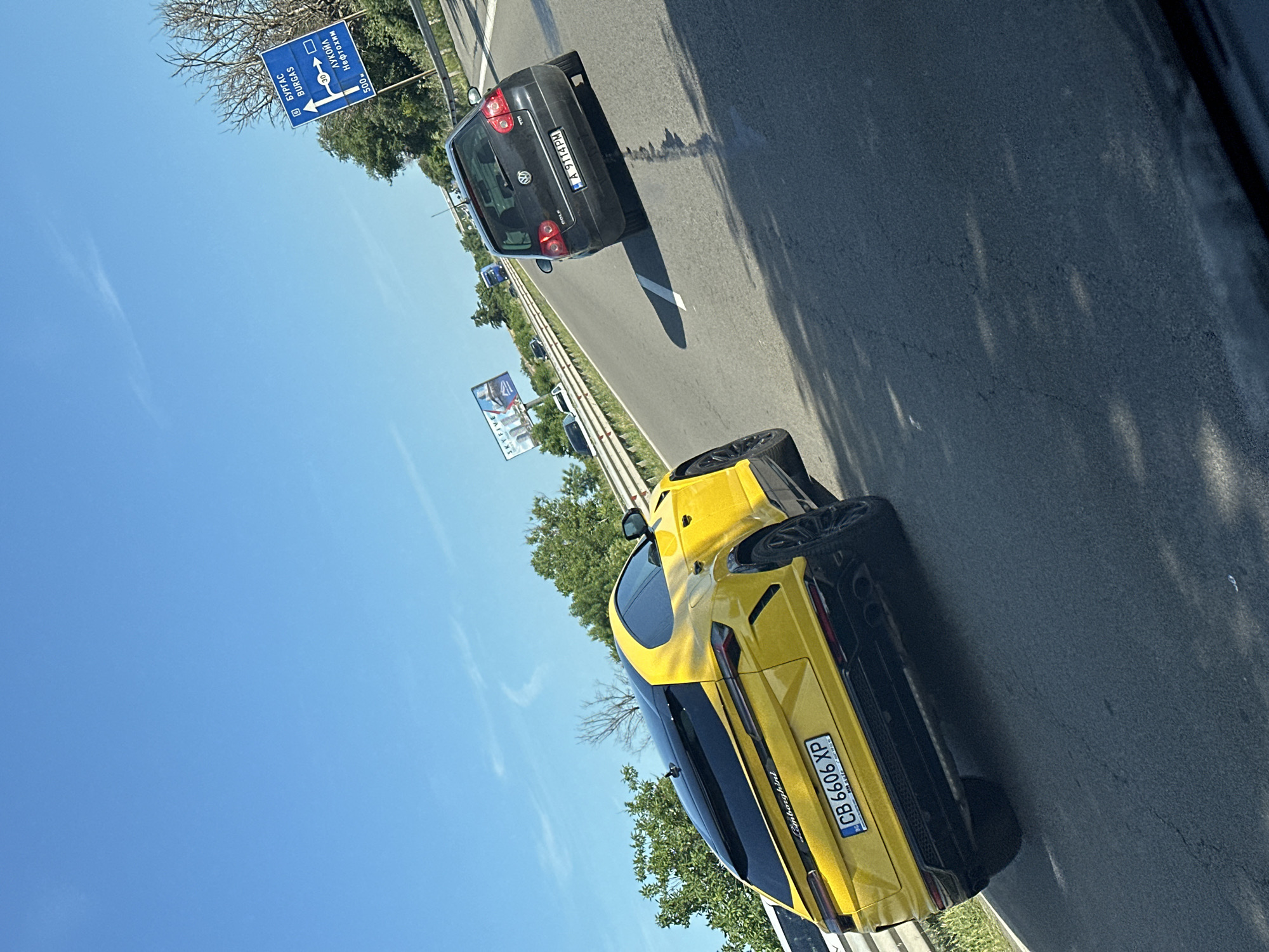 Luxury and everyday vehicles spotted across highway and parking areas