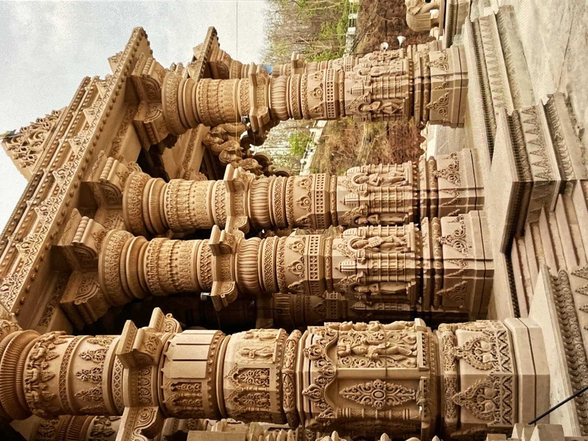Ornate sandstone temple pillars with detailed sculptural carvings