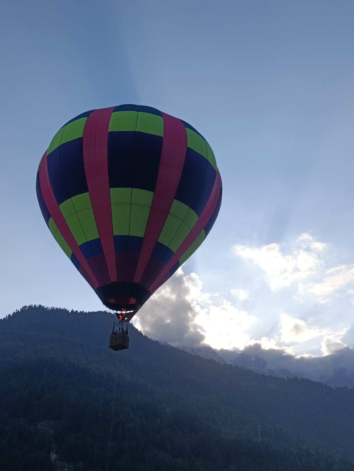 Colorful hot air balloon soars over Himalayan mountains in Vashisht