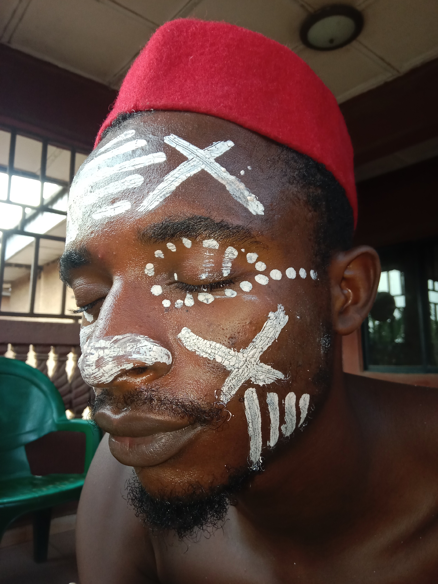 Man spotted with ceremonial face paint in outdoor setting