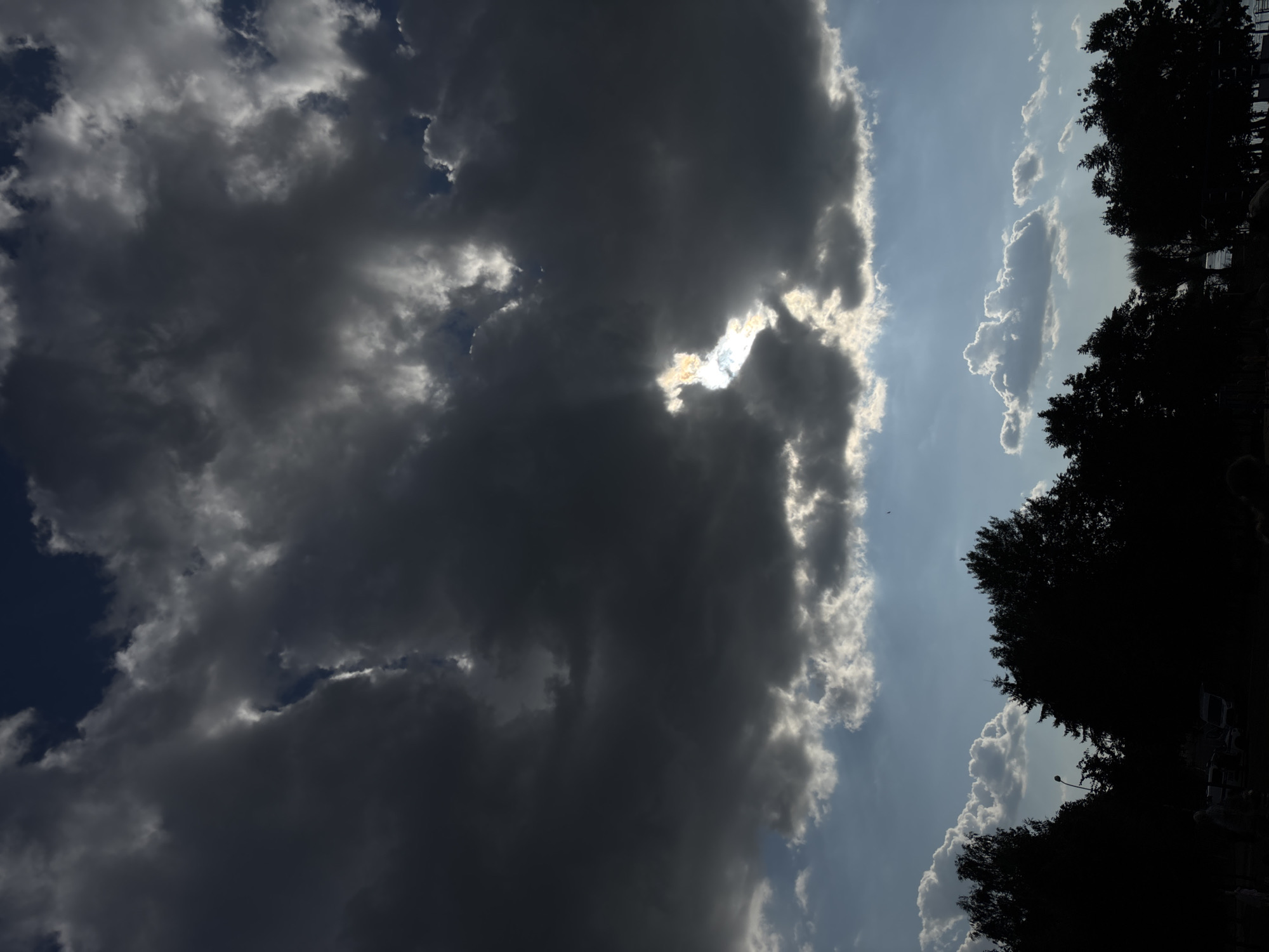 Storm clouds and sunlight compete across a dramatic sky.