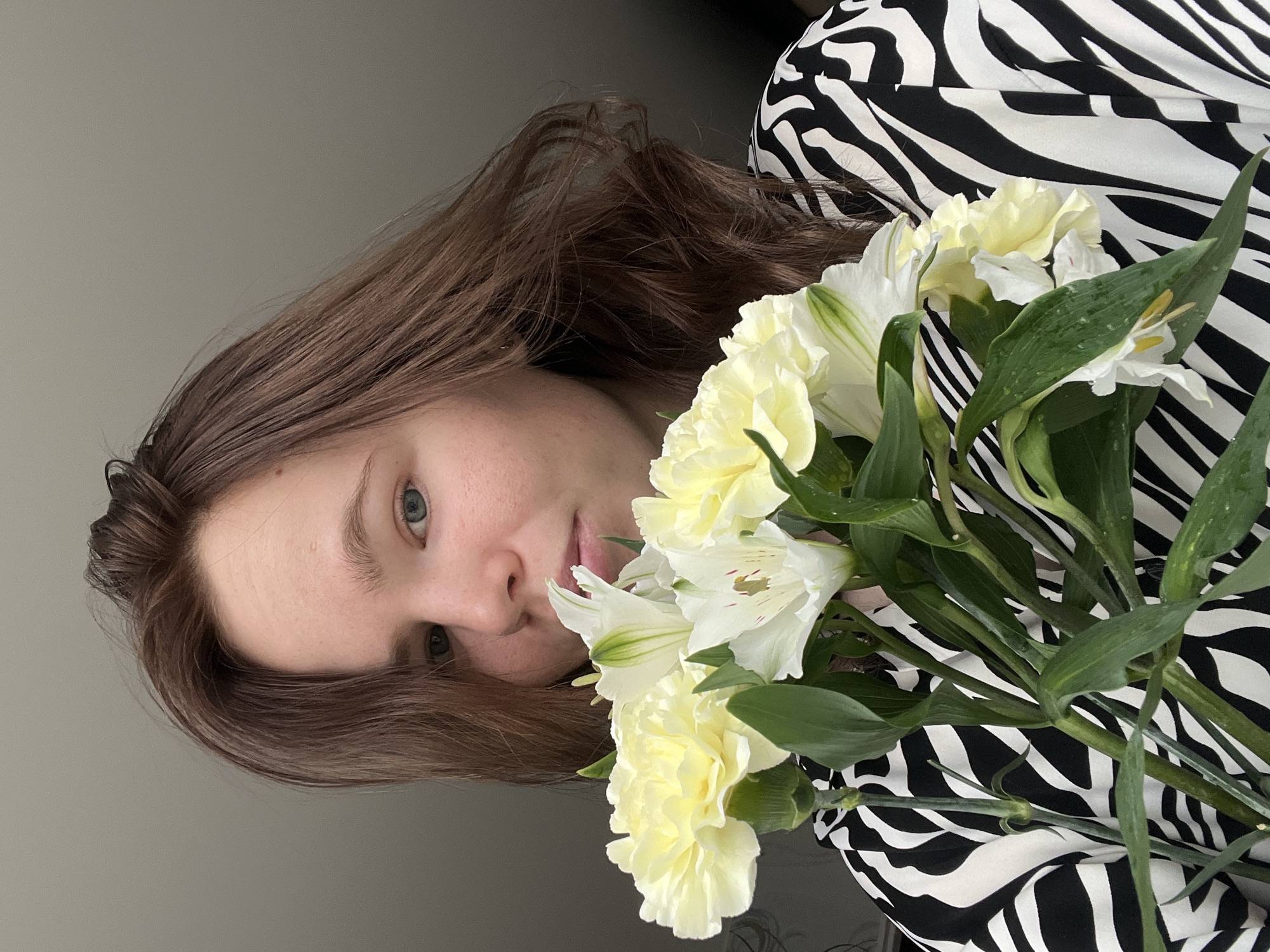 Woman takes mirror selfies with flowers in Chaikovsky