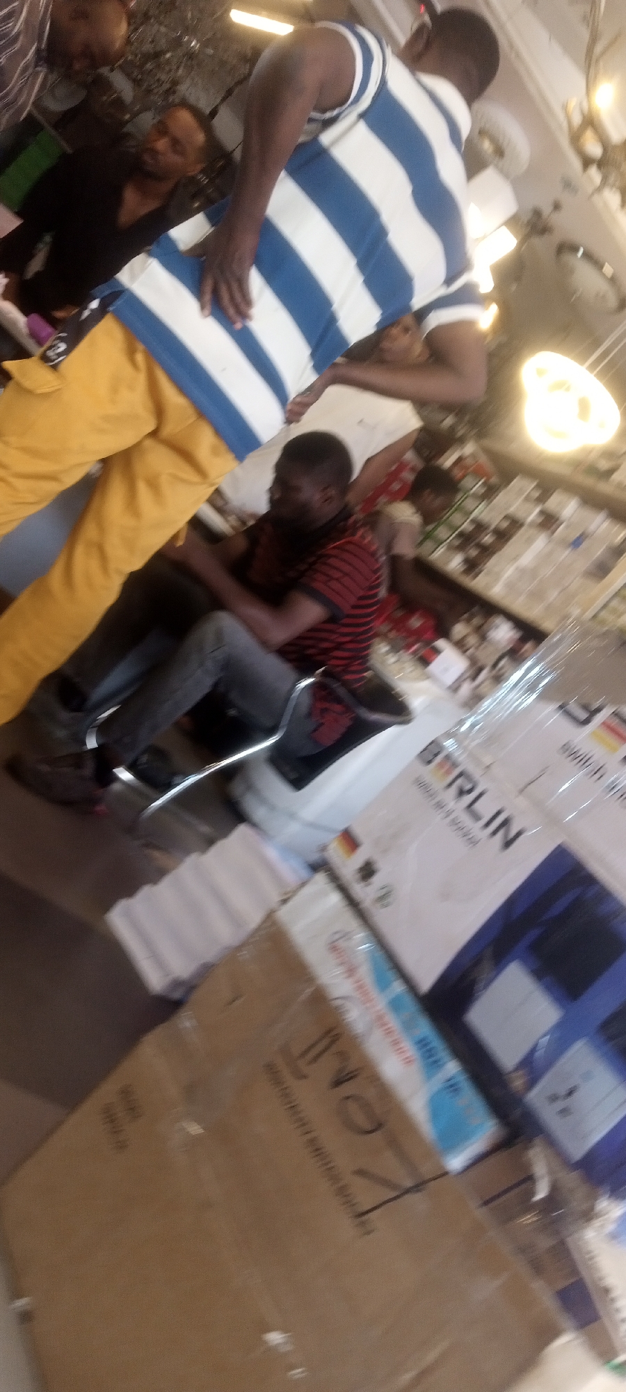 Two men observed in shop, one standing, one seated