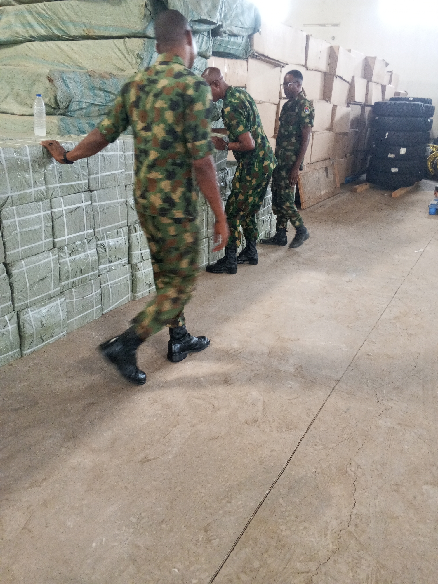 Military personnel observed handling packaged goods in warehouse facility