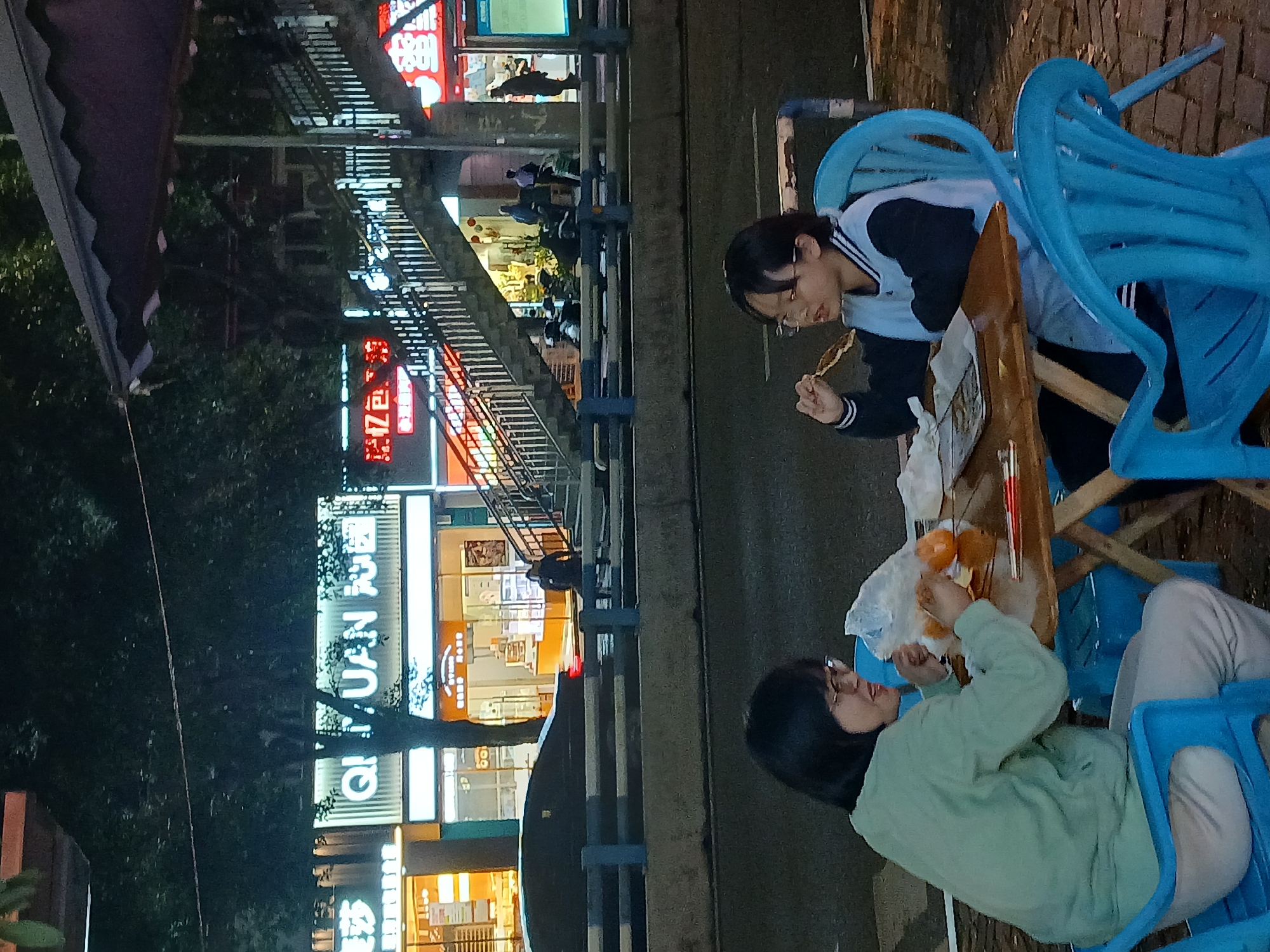 Young women share street food meal in Shapingba District