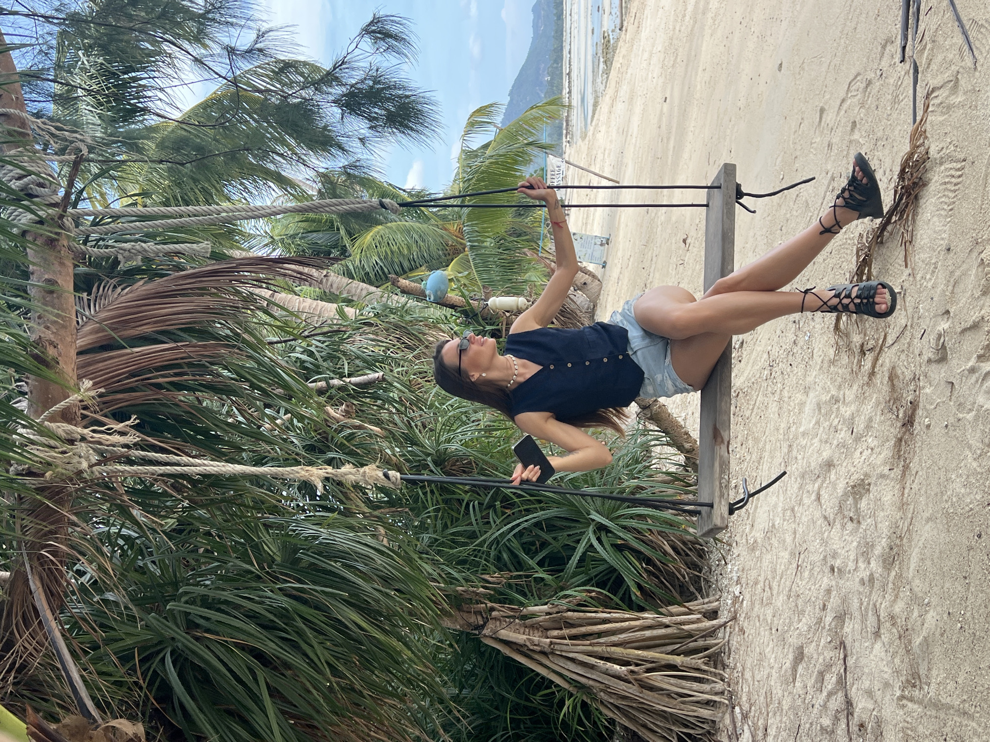 Woman relaxes on beach swing in Thailand morning scene