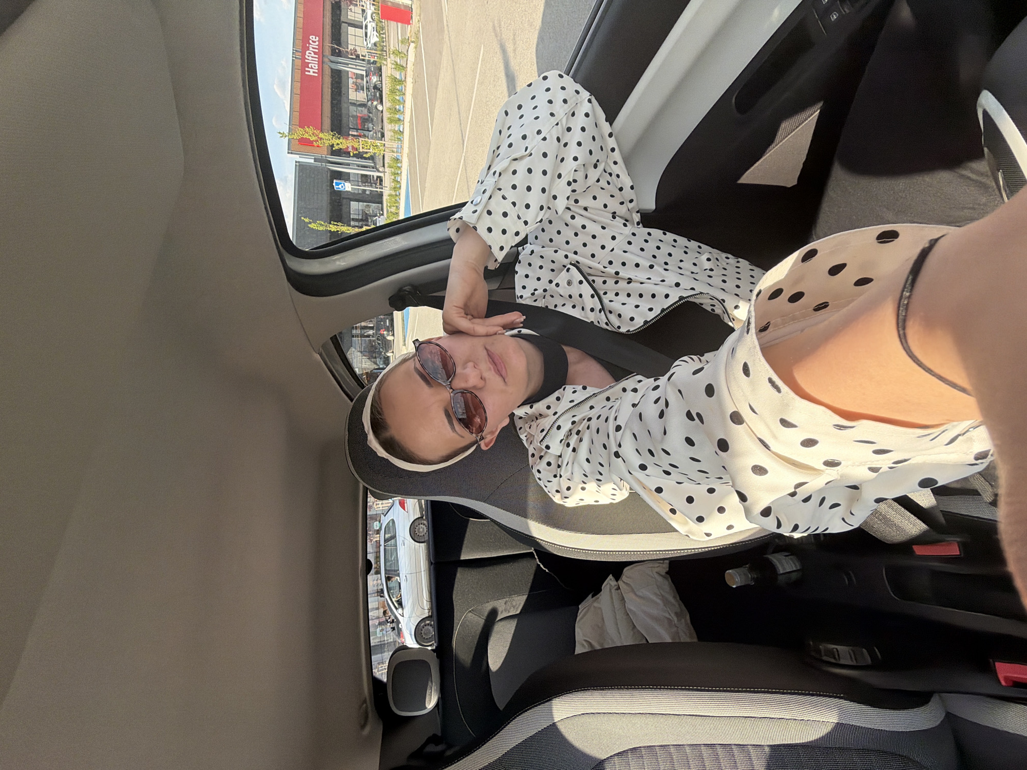 Woman in polka-dot jacket observed in car passenger seat, Sofia