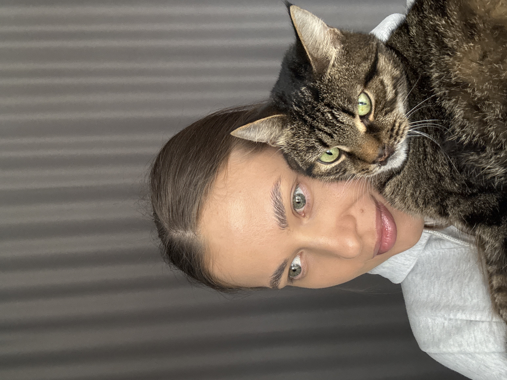 Woman poses with tabby cat in casual photo session