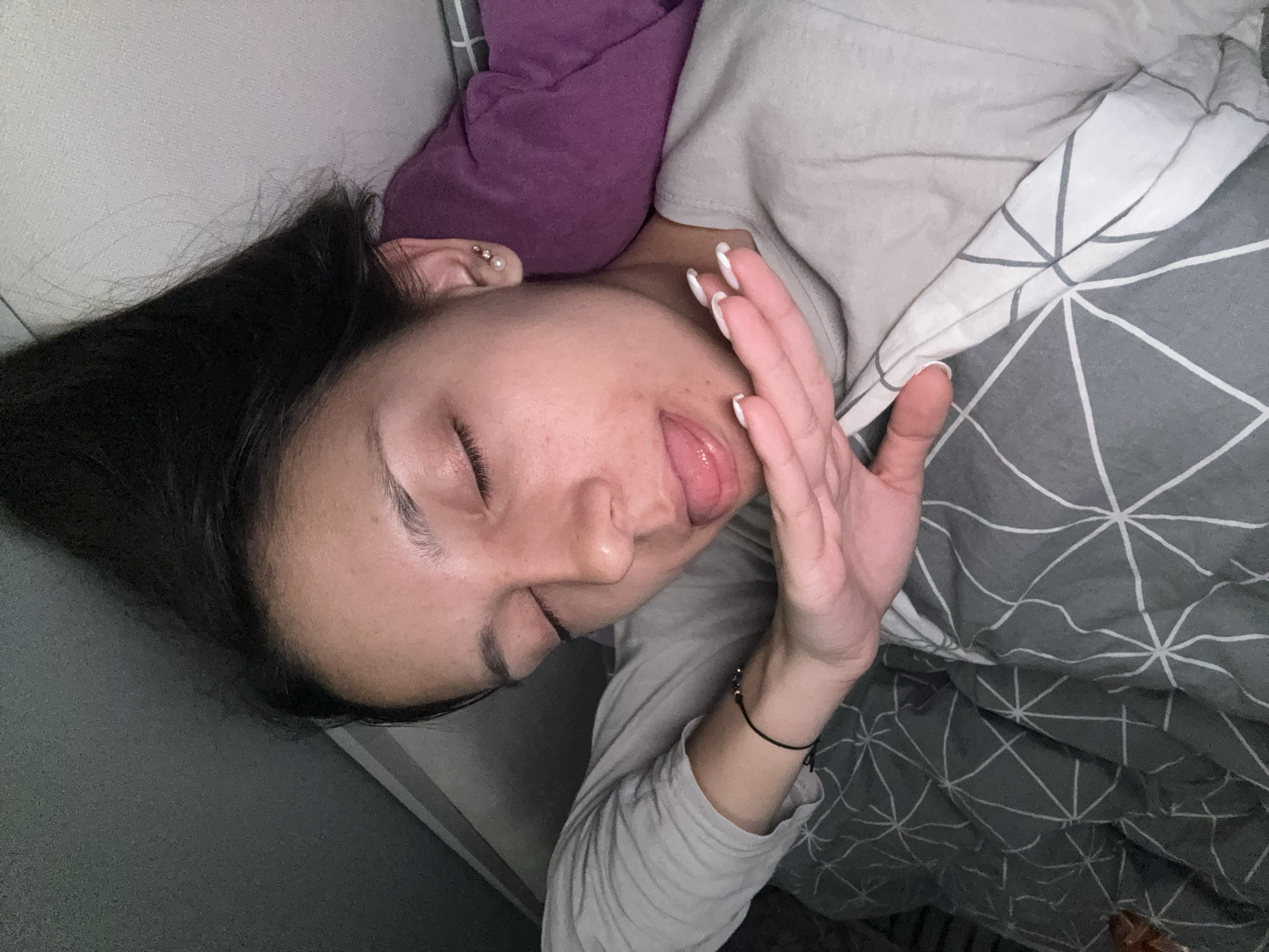 Woman relaxes in bed with snacks and laptop in Sofia
