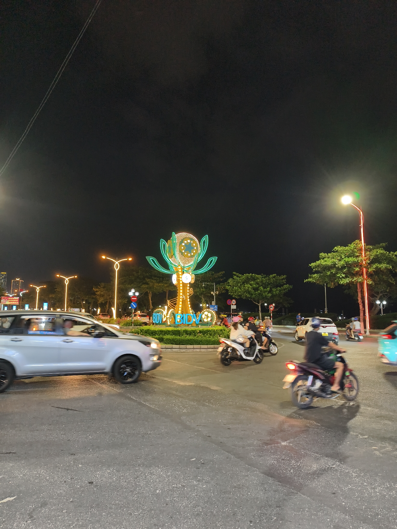 Nighttime urban scenes capture traffic, coffee truck, group gathering