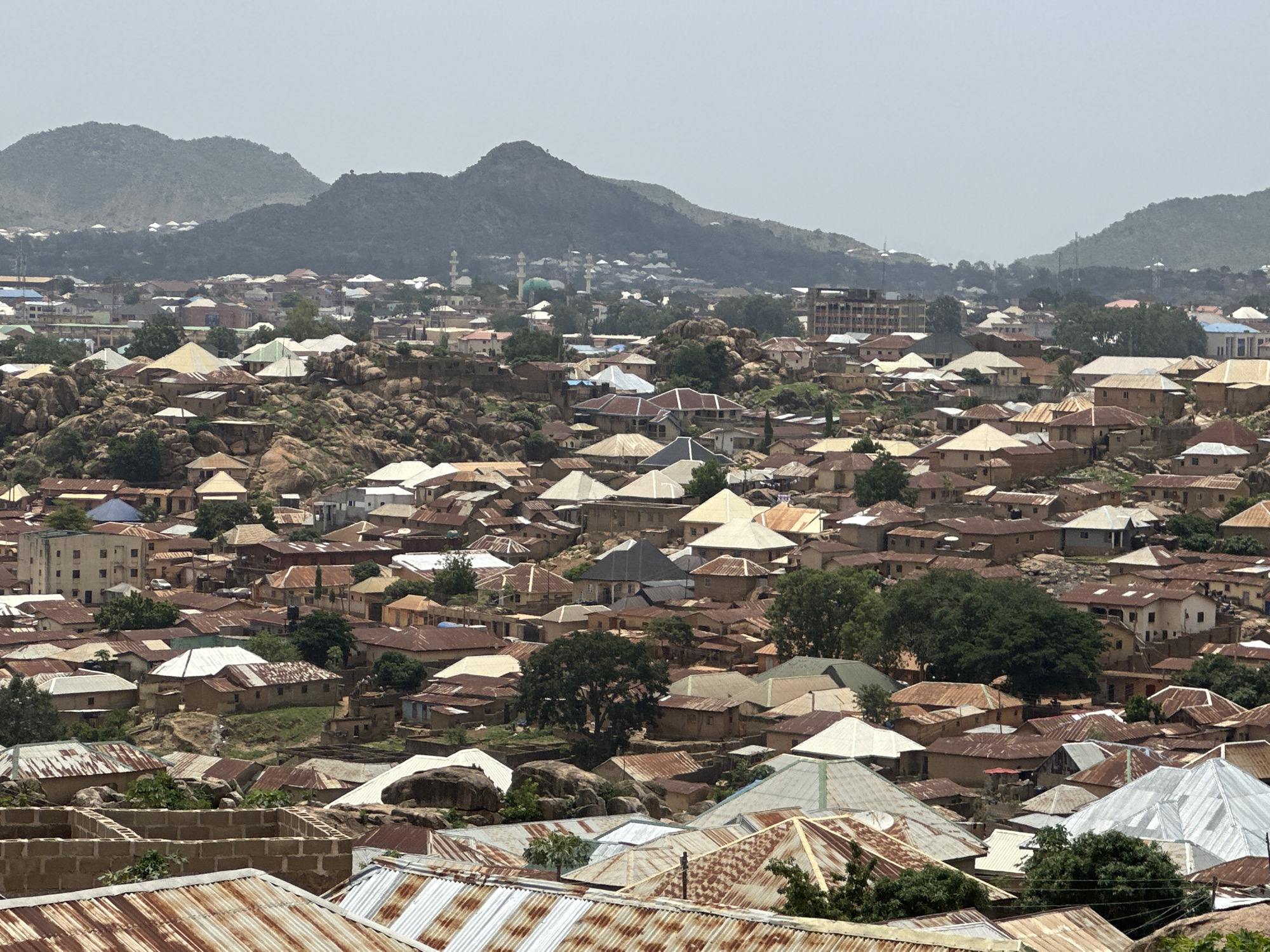 Aerial views capture dense residential Jos neighborhood with metal roofs