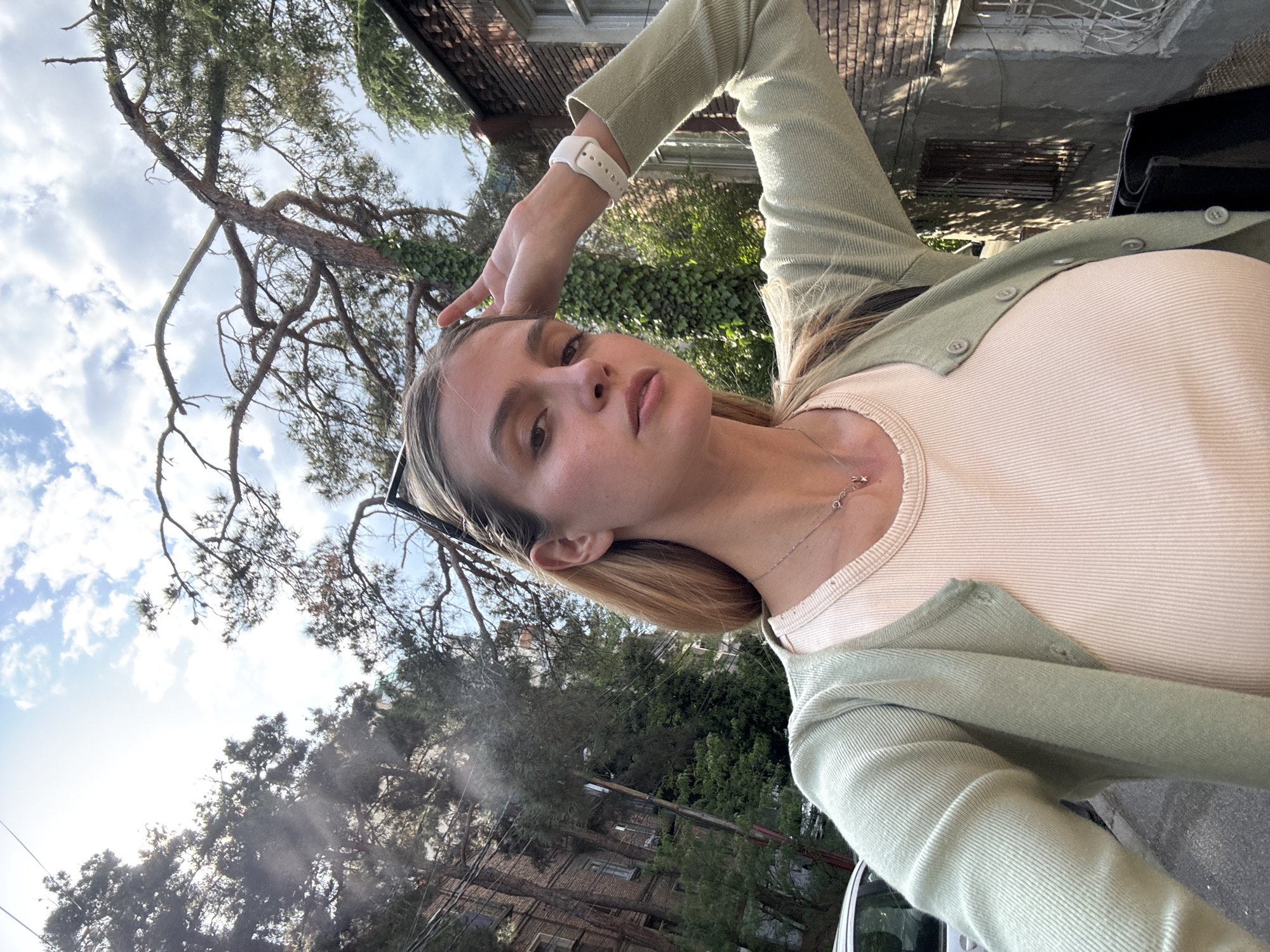 Woman takes selfies near brick building in Tbilisi
