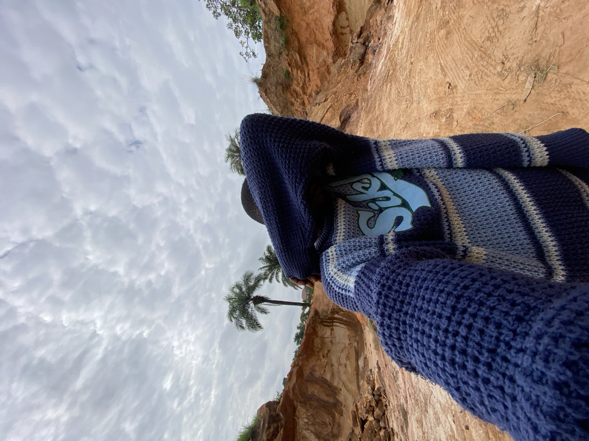 Person in blue sweater photographed from below in Igbara