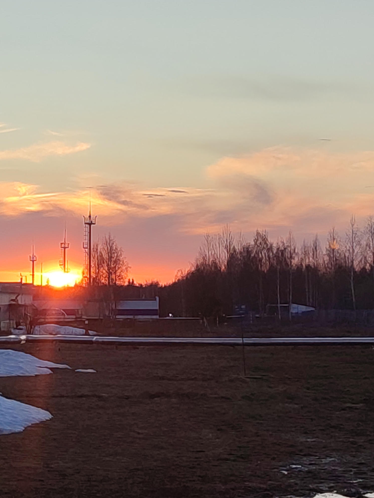 Sunset captured over urban landscape with communication towers