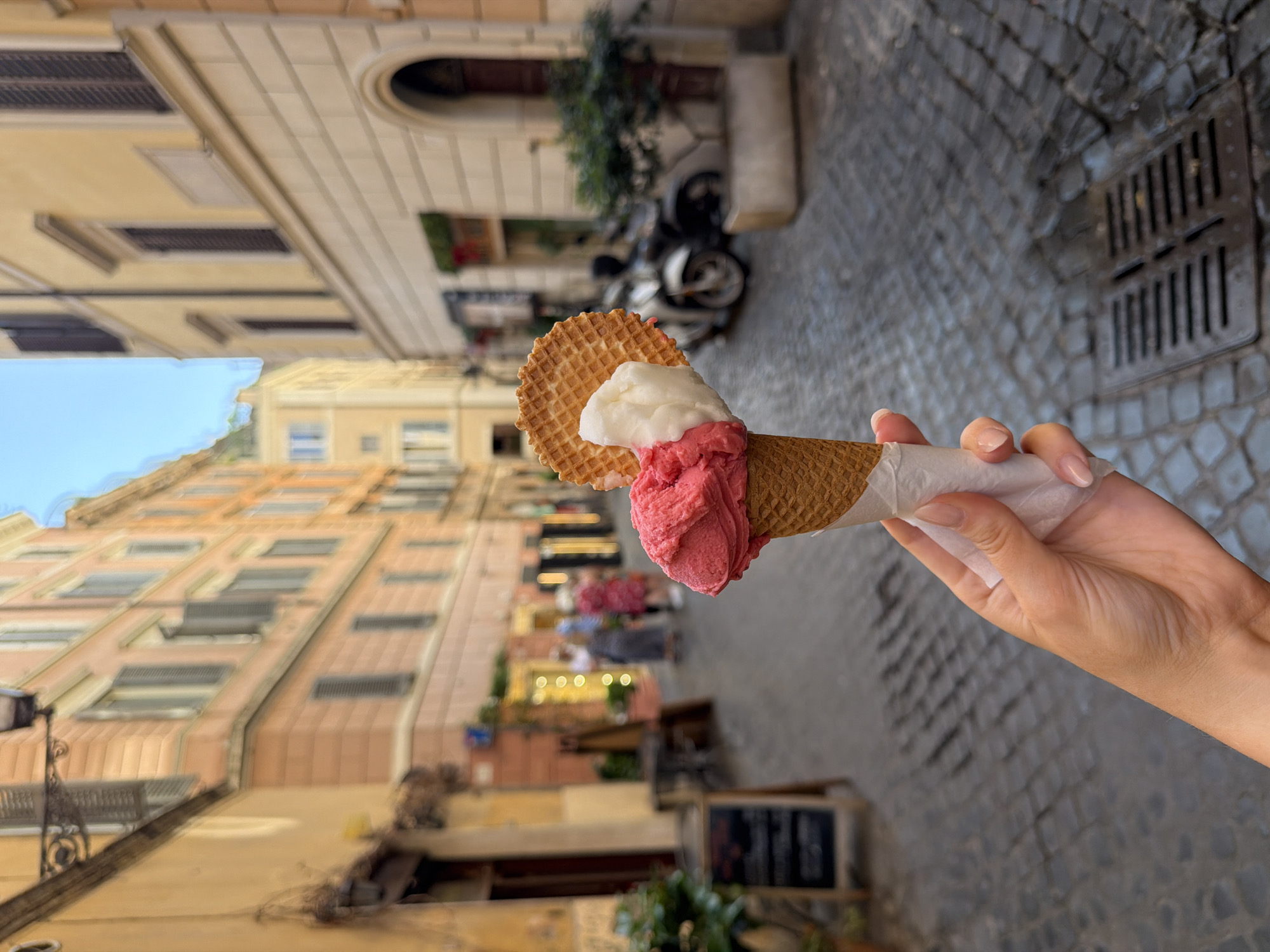 Person enjoys gelato on Rome street