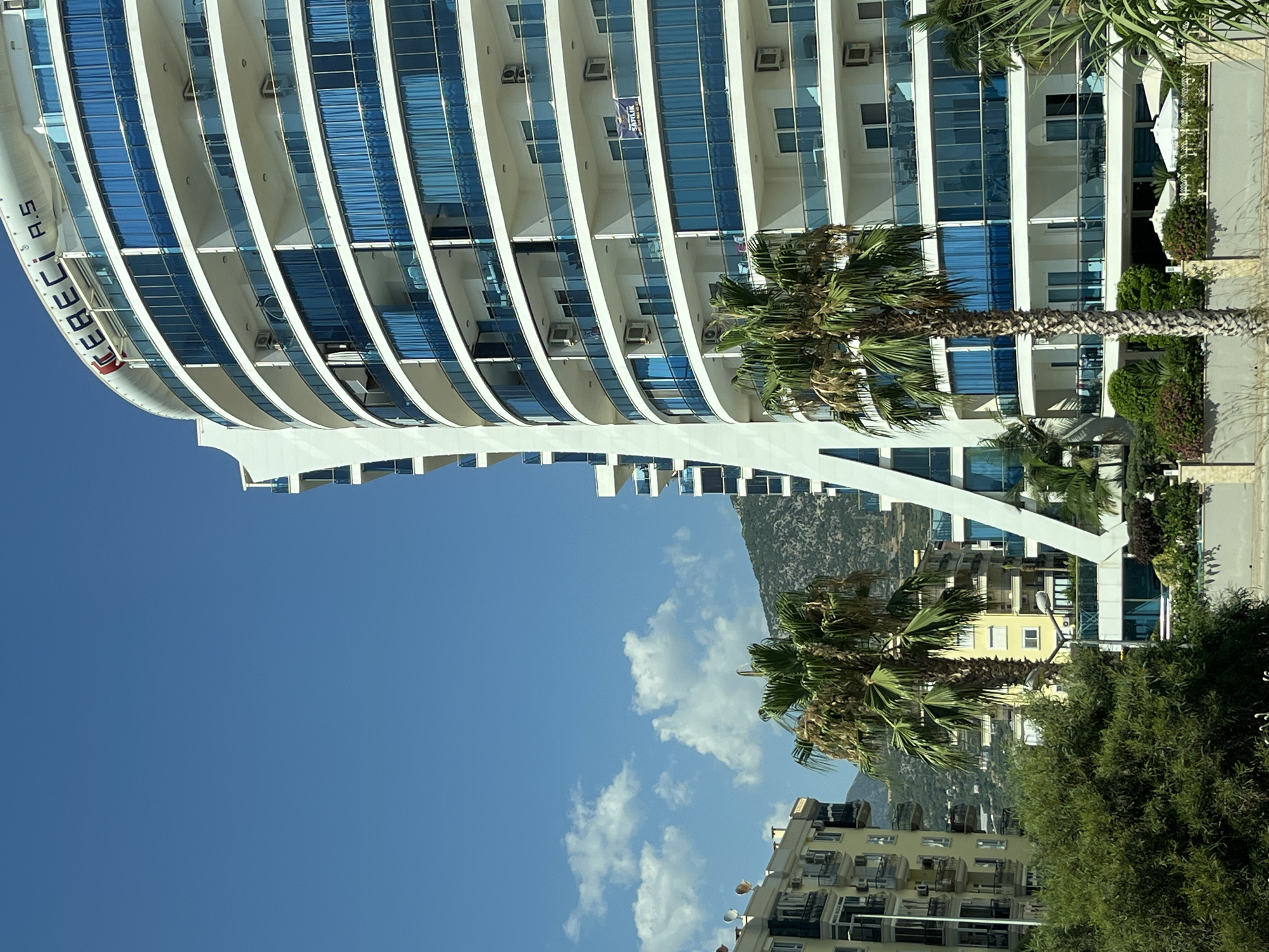Curved white building with blue balconies in Alanya, Turkey