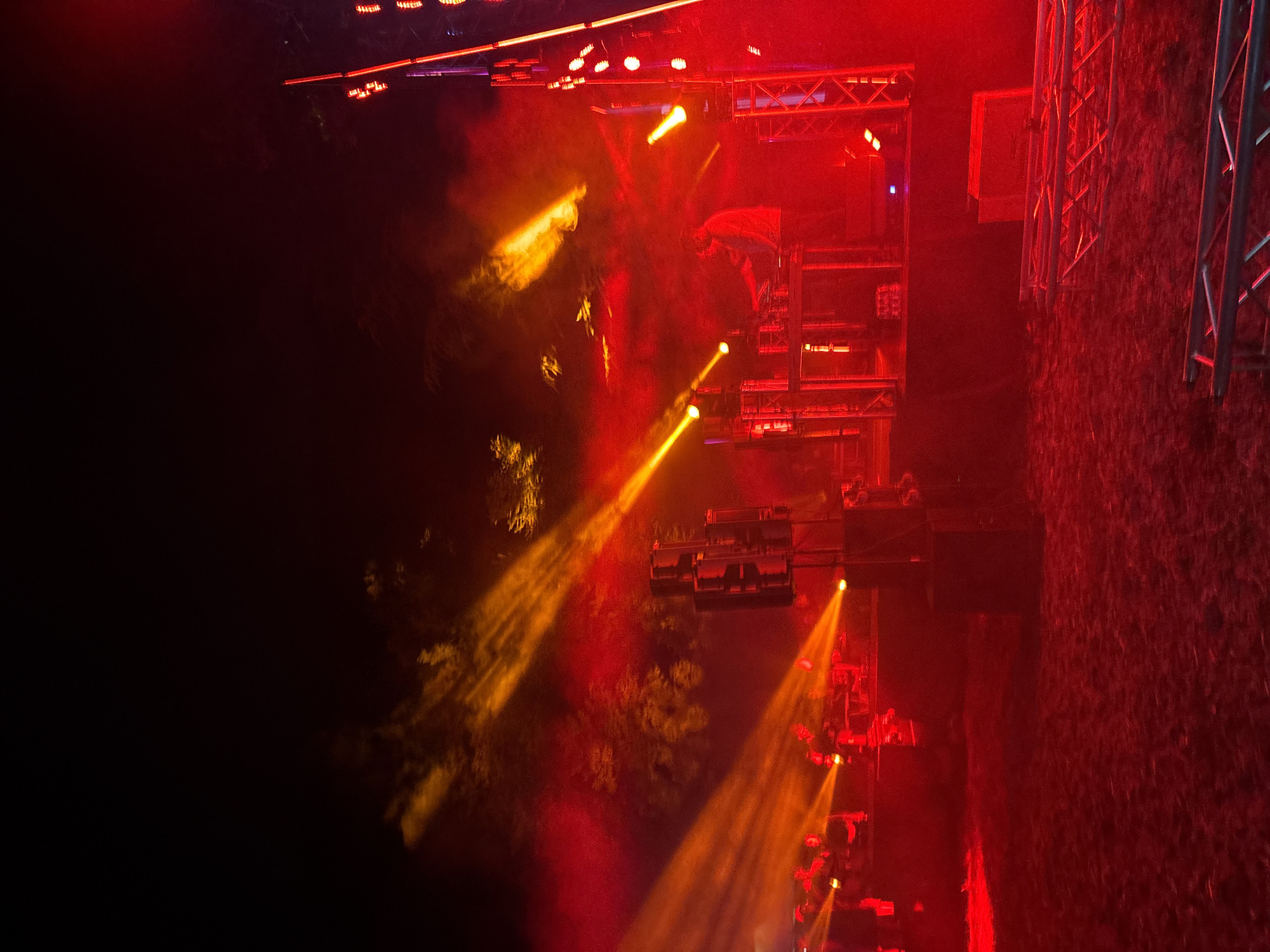 Outdoor night concert with DJ set and lit triangular stage