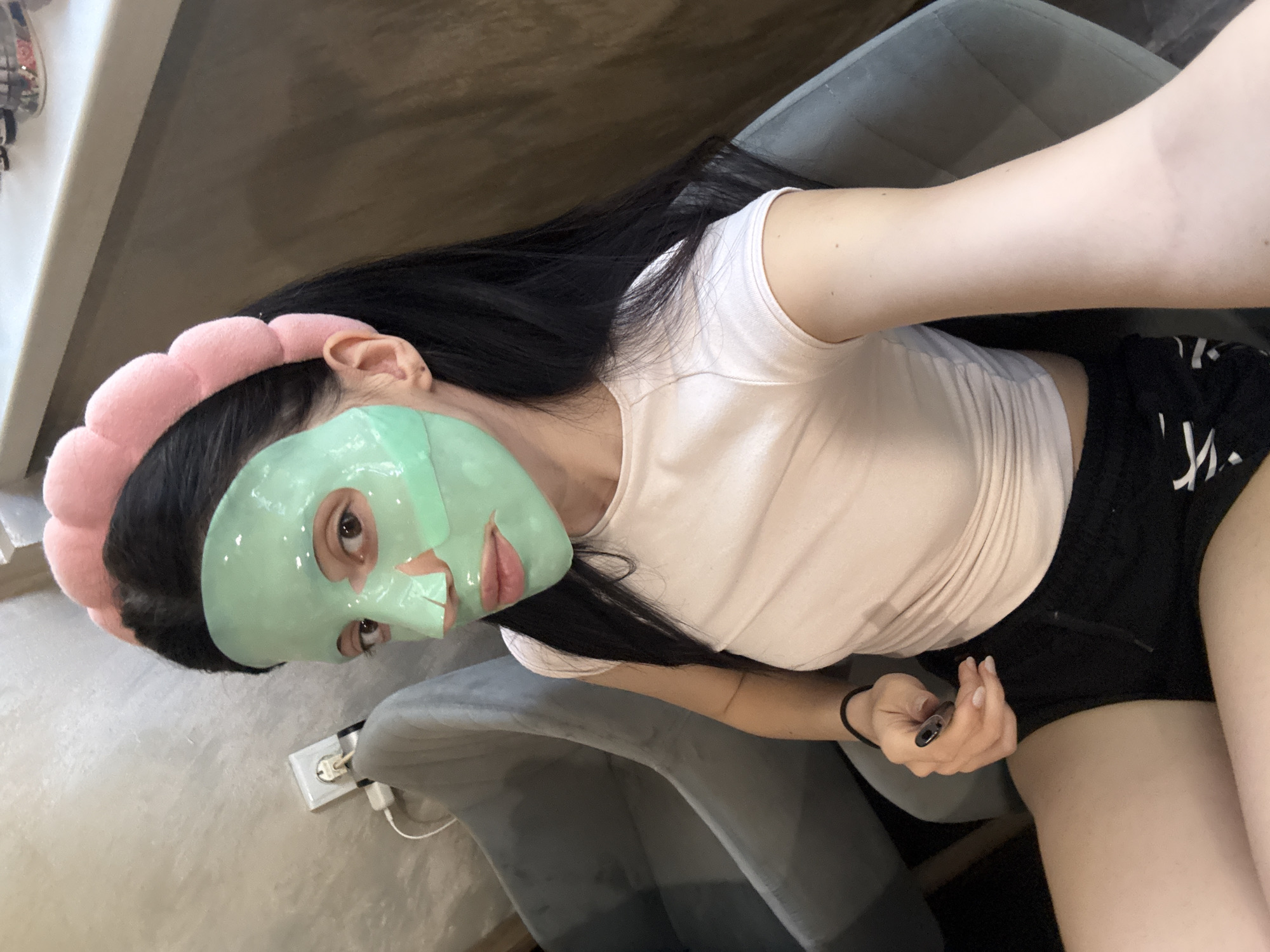 Woman documents skincare routine with green face mask in Sofia