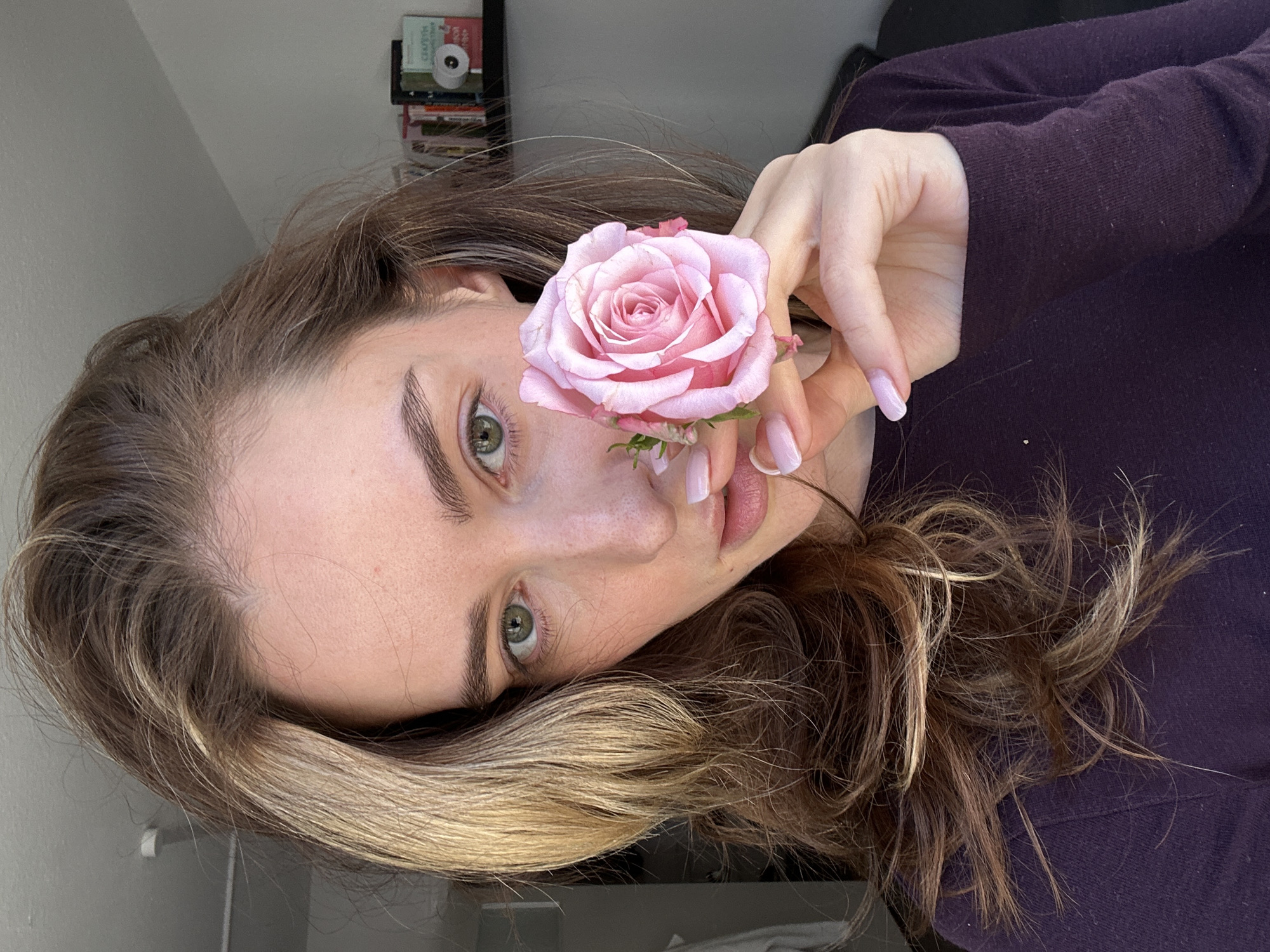 Woman poses with pink rose in Kiel portrait session