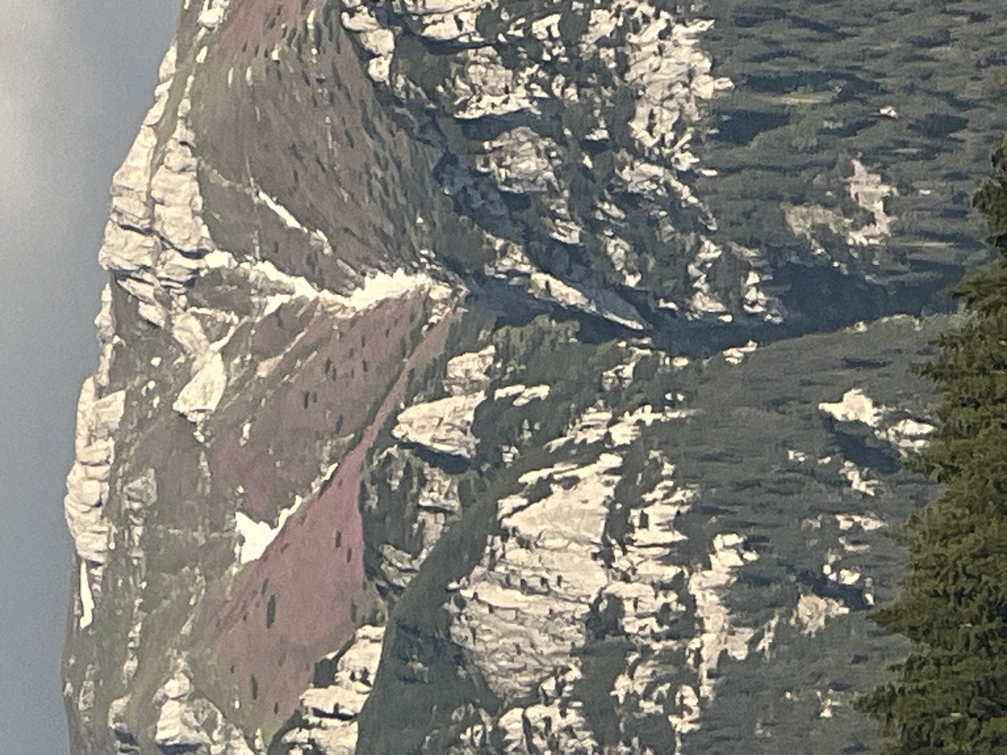Rocky mountain range with forested slopes and a hillside village