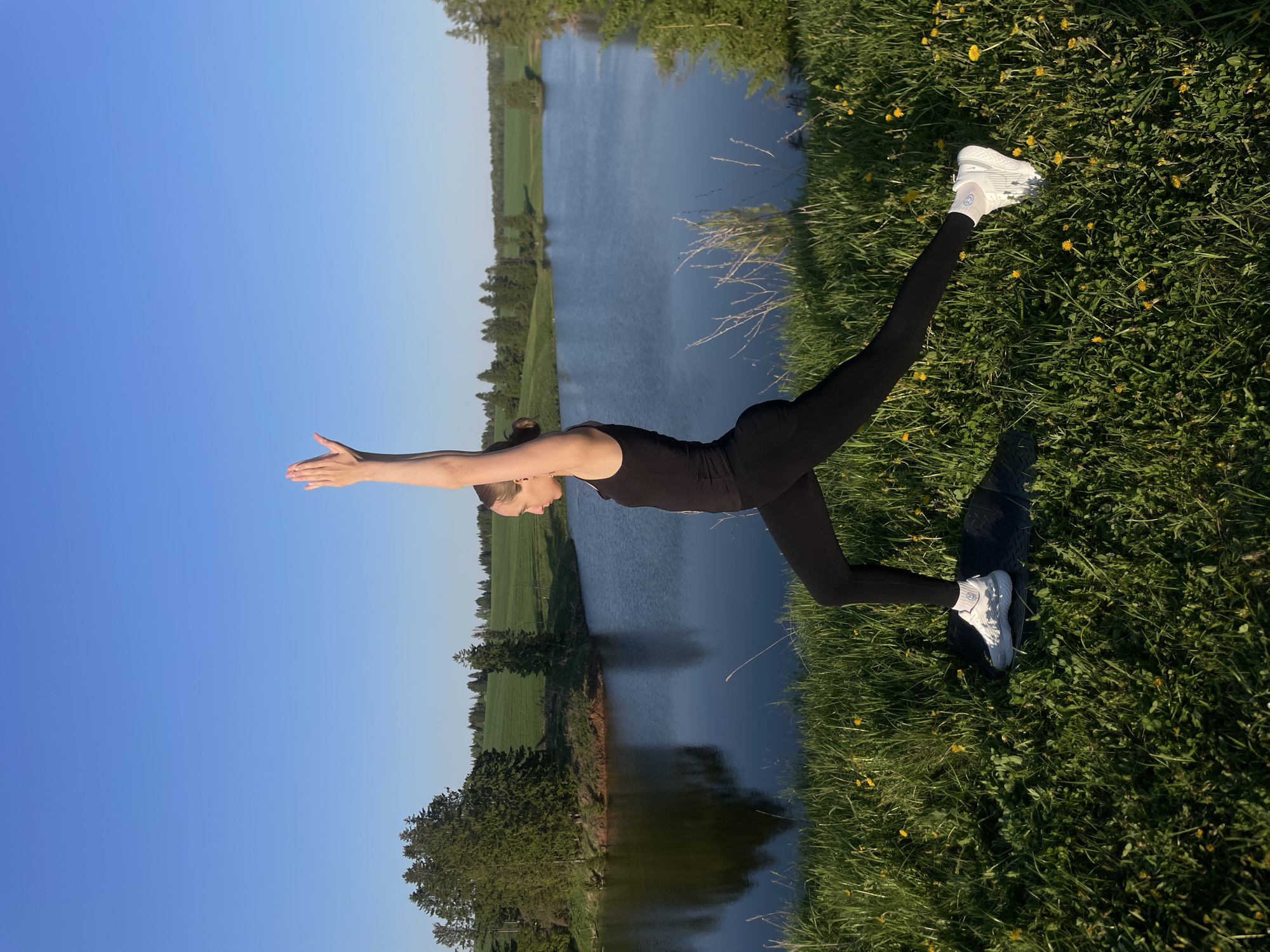 Yoga practitioners exercise by waterside in Podshivalovo, Russia