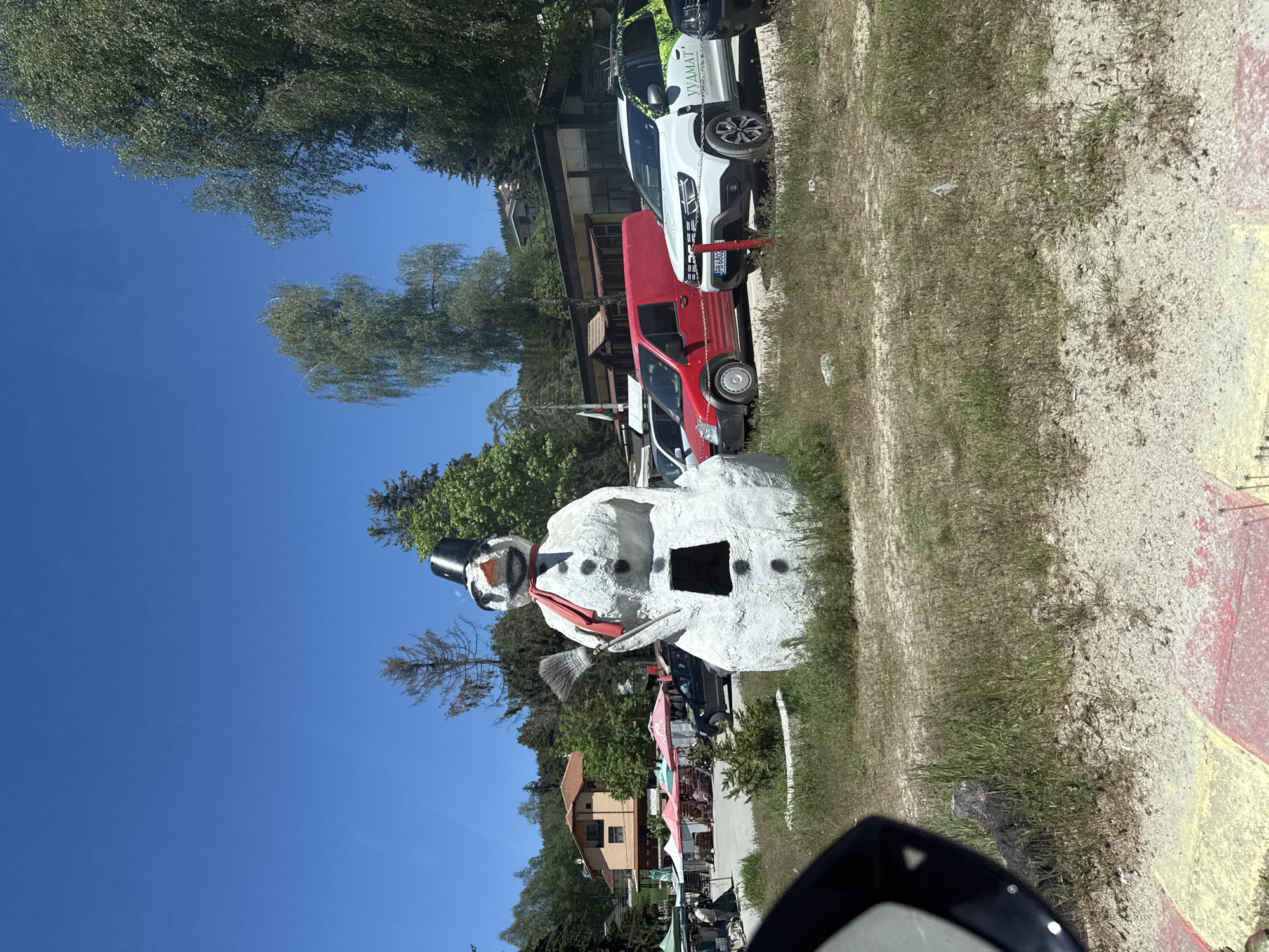 Car journey documented through small town with snowman statue