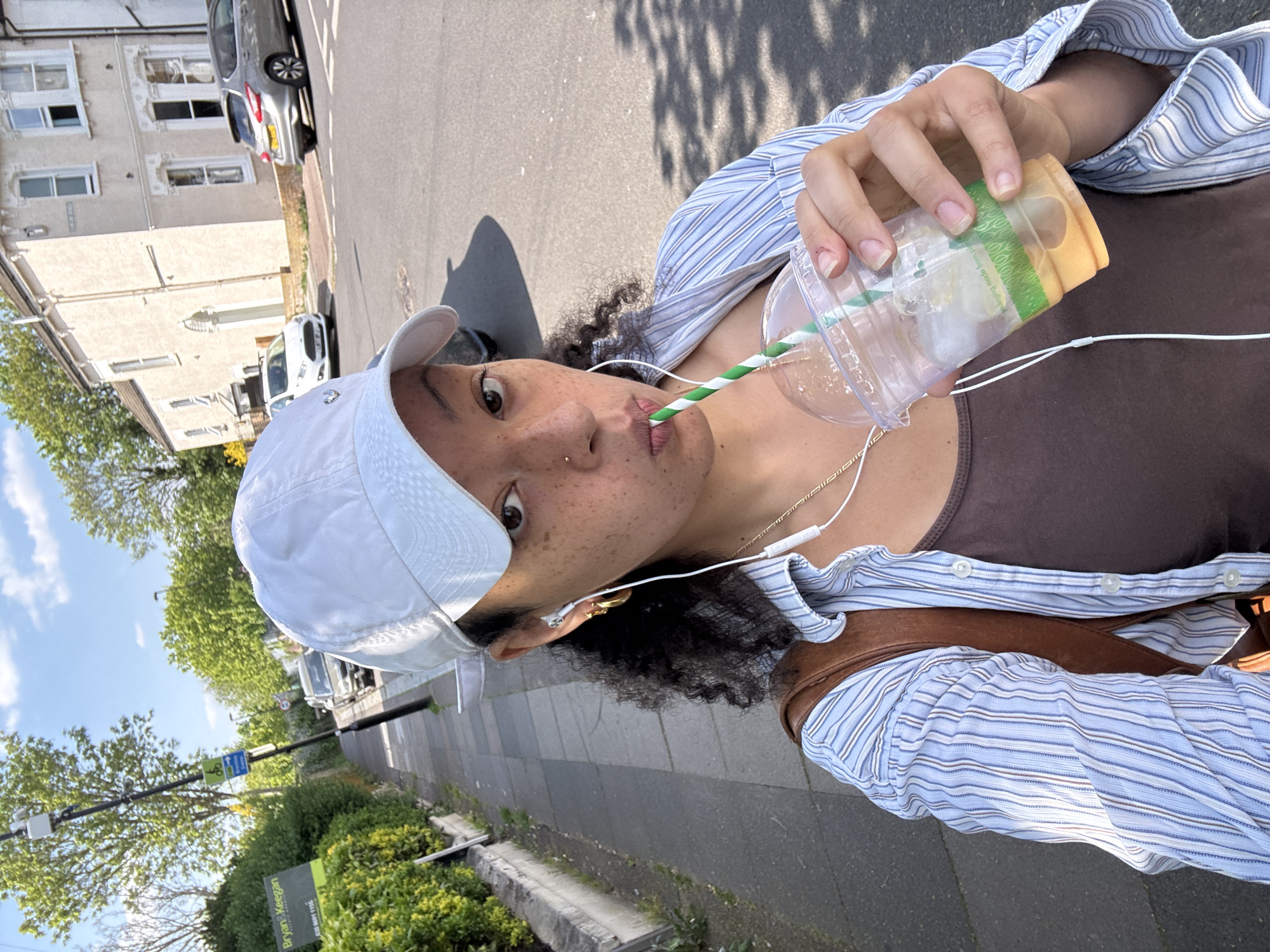 Person enjoys iced coffee on sunny afternoon in London