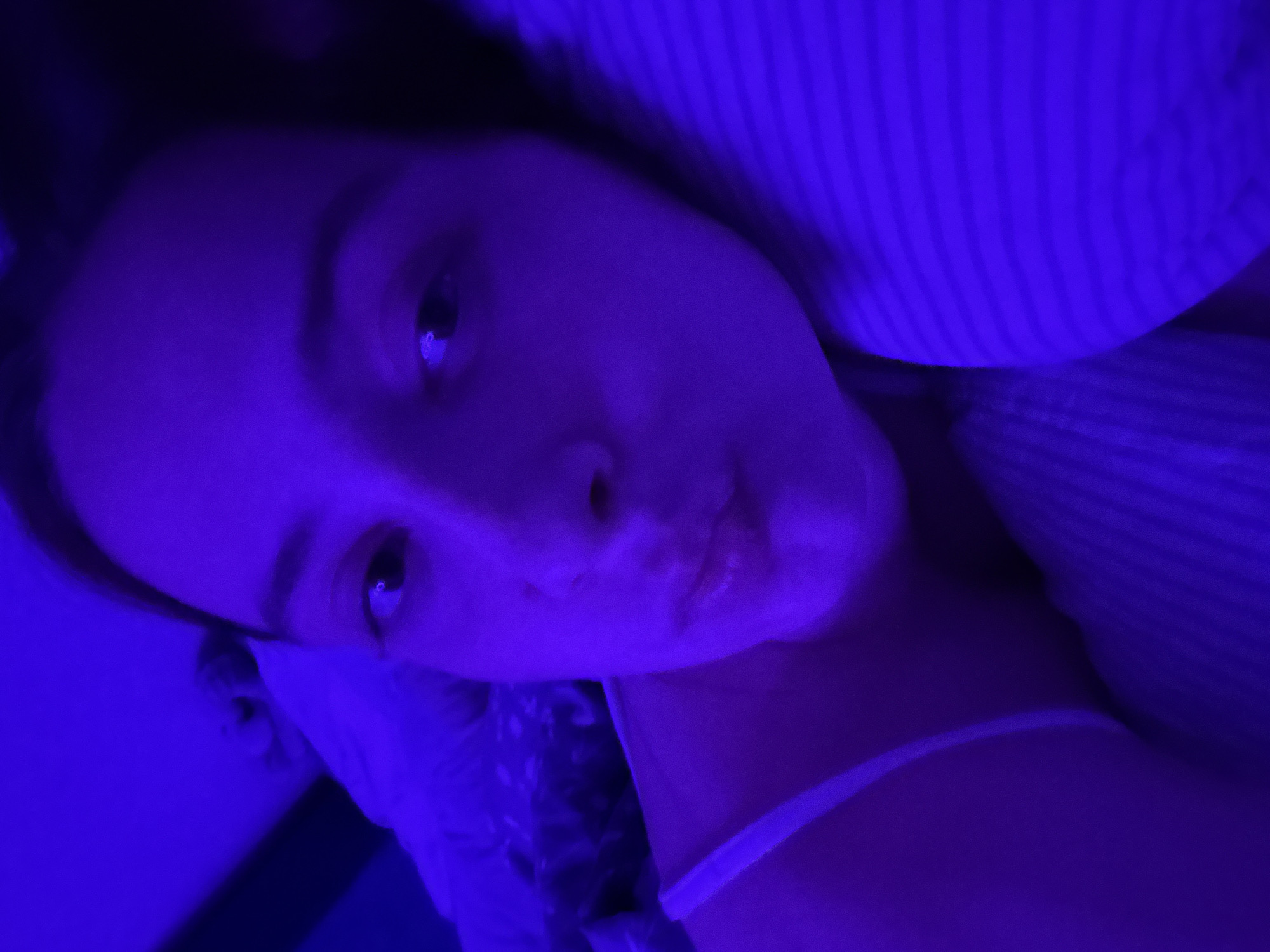 Young woman captures personal moments during bedroom photo session