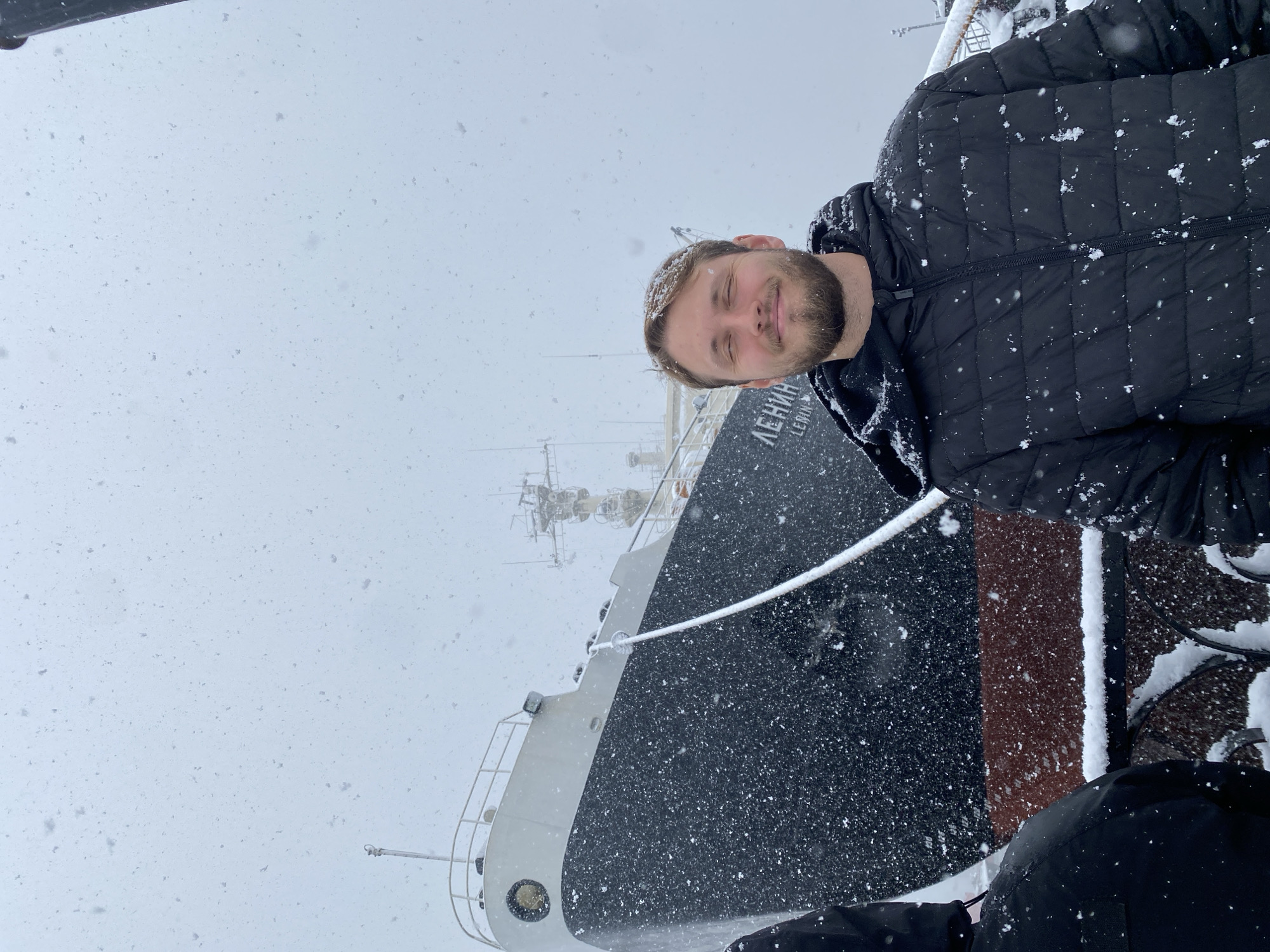 Tourist photographs Lenin Icebreaker museum in snowy Murmansk