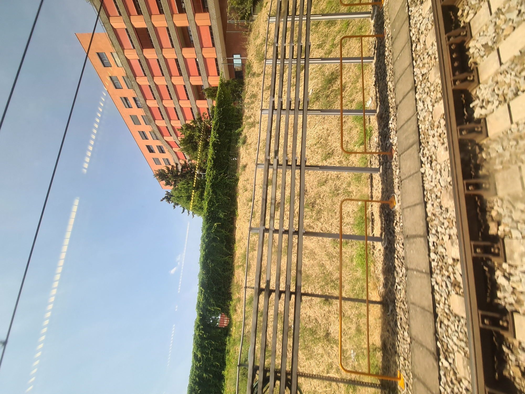Train window view of an orange building along Vienna's rail corridor