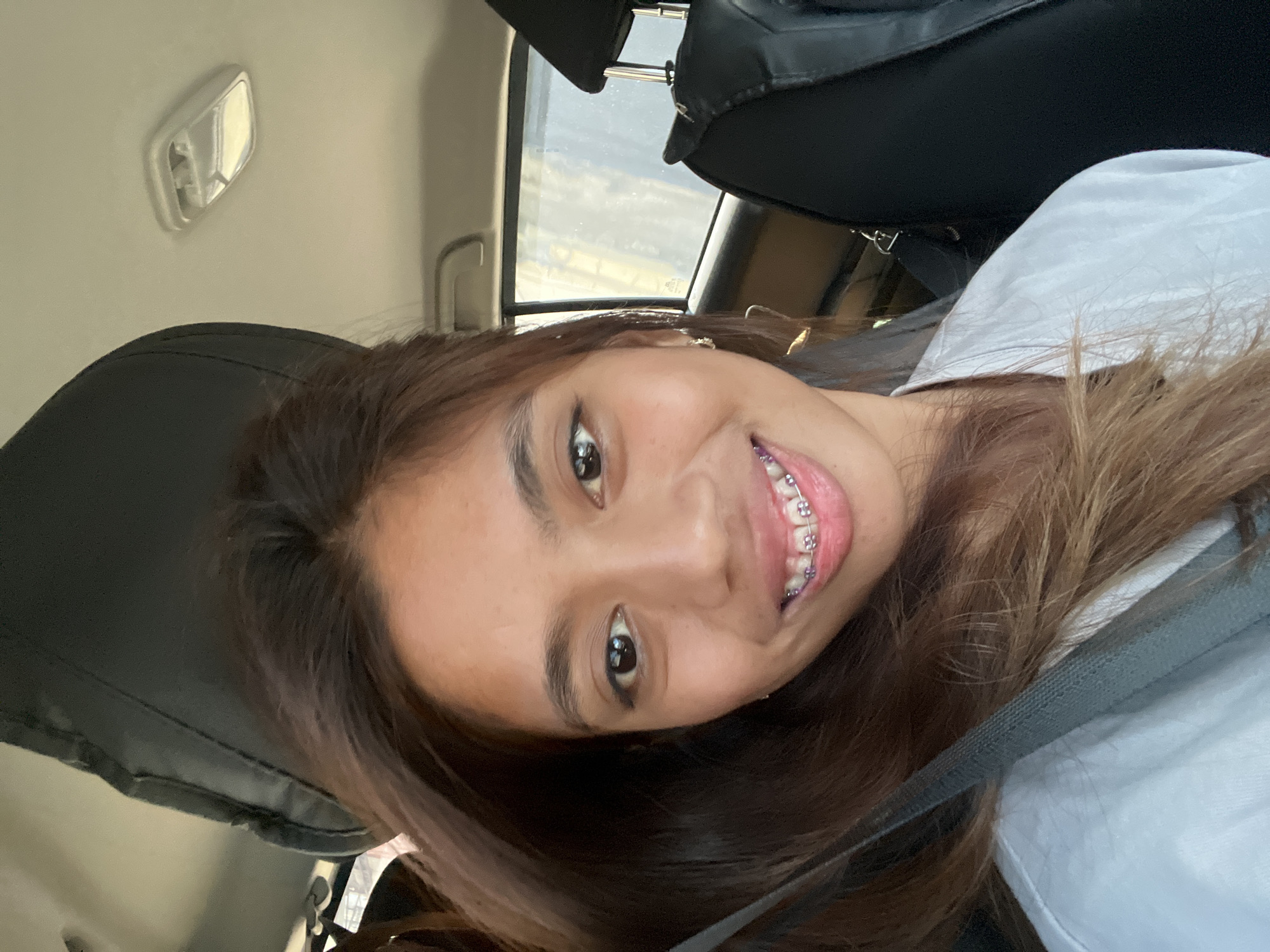 Woman takes playful selfies during early morning car ride