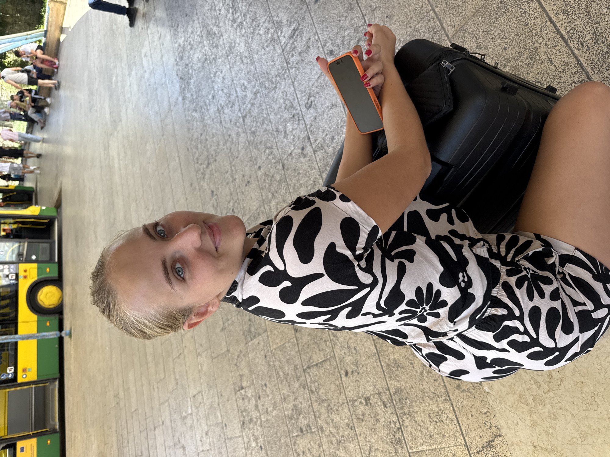 Young woman travels through Pula, Croatia with suitcase