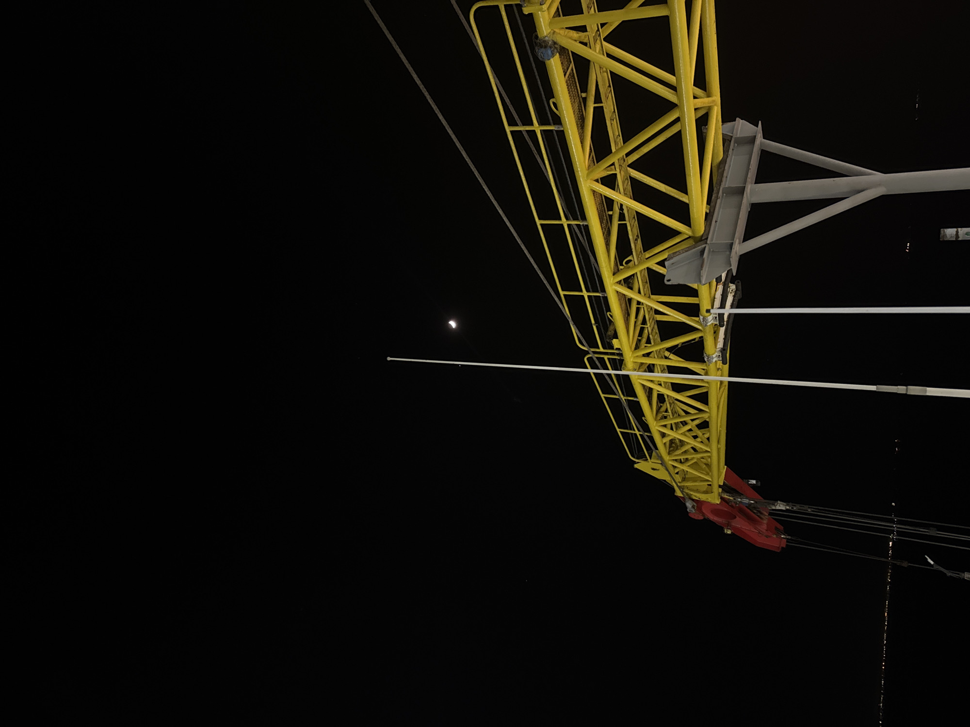 Industrial crane or drilling rig photographed at night in Italy