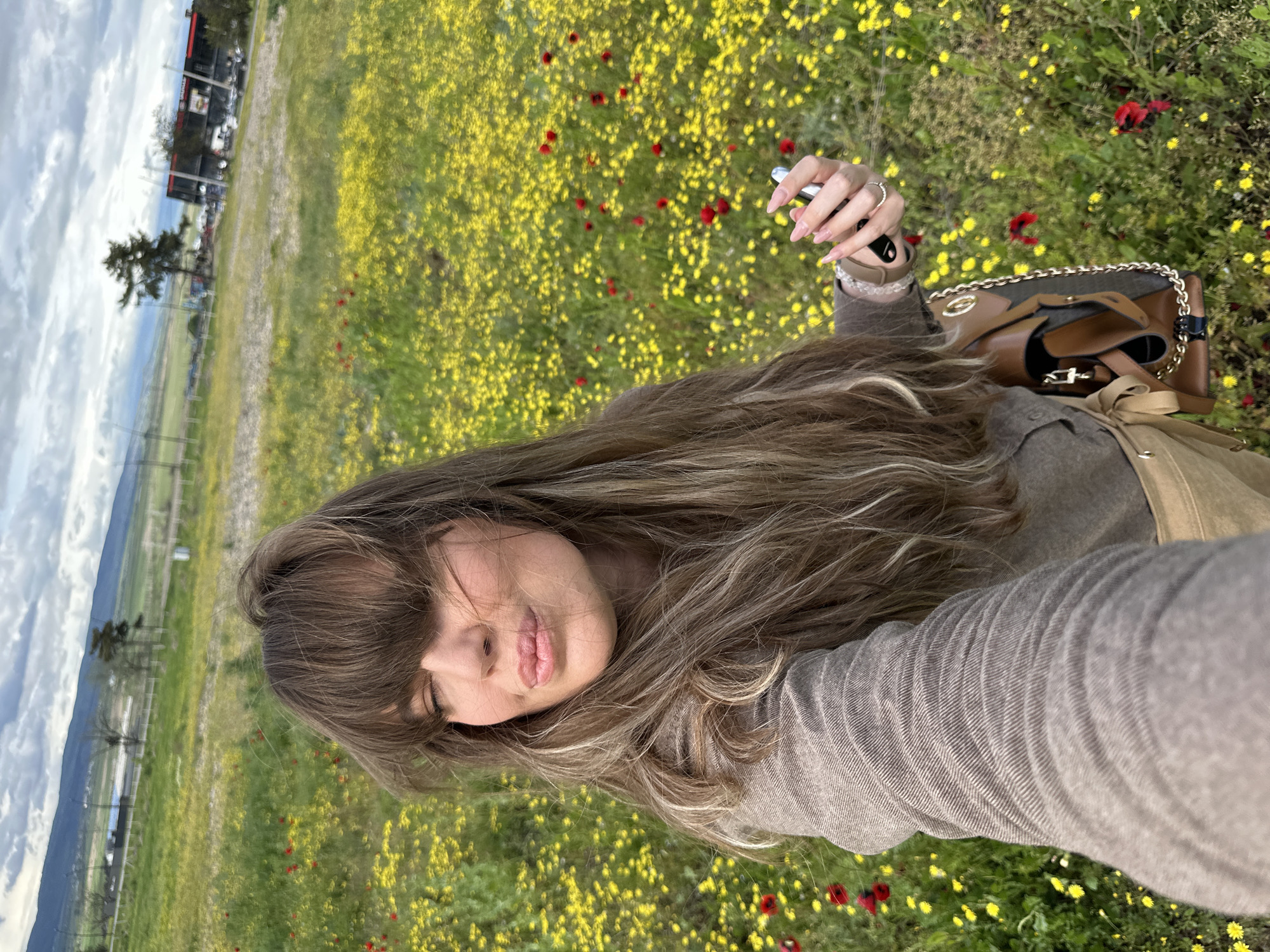Woman takes selfies in wildflower field near Marneuli, Georgia