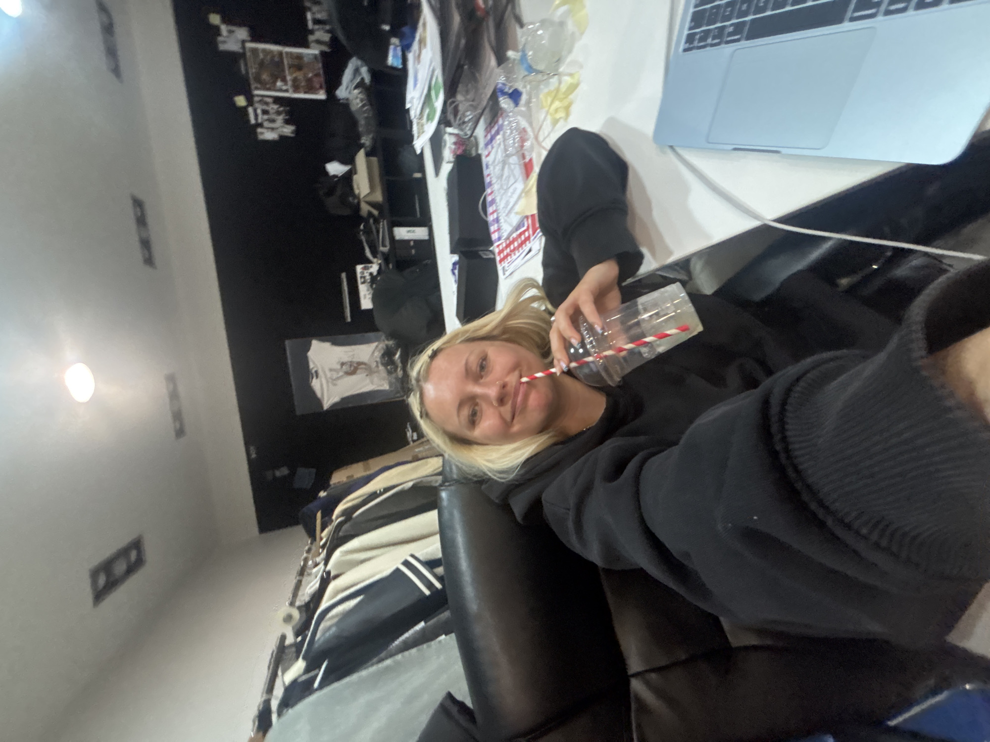 Woman relaxes with drink and laptop in London home