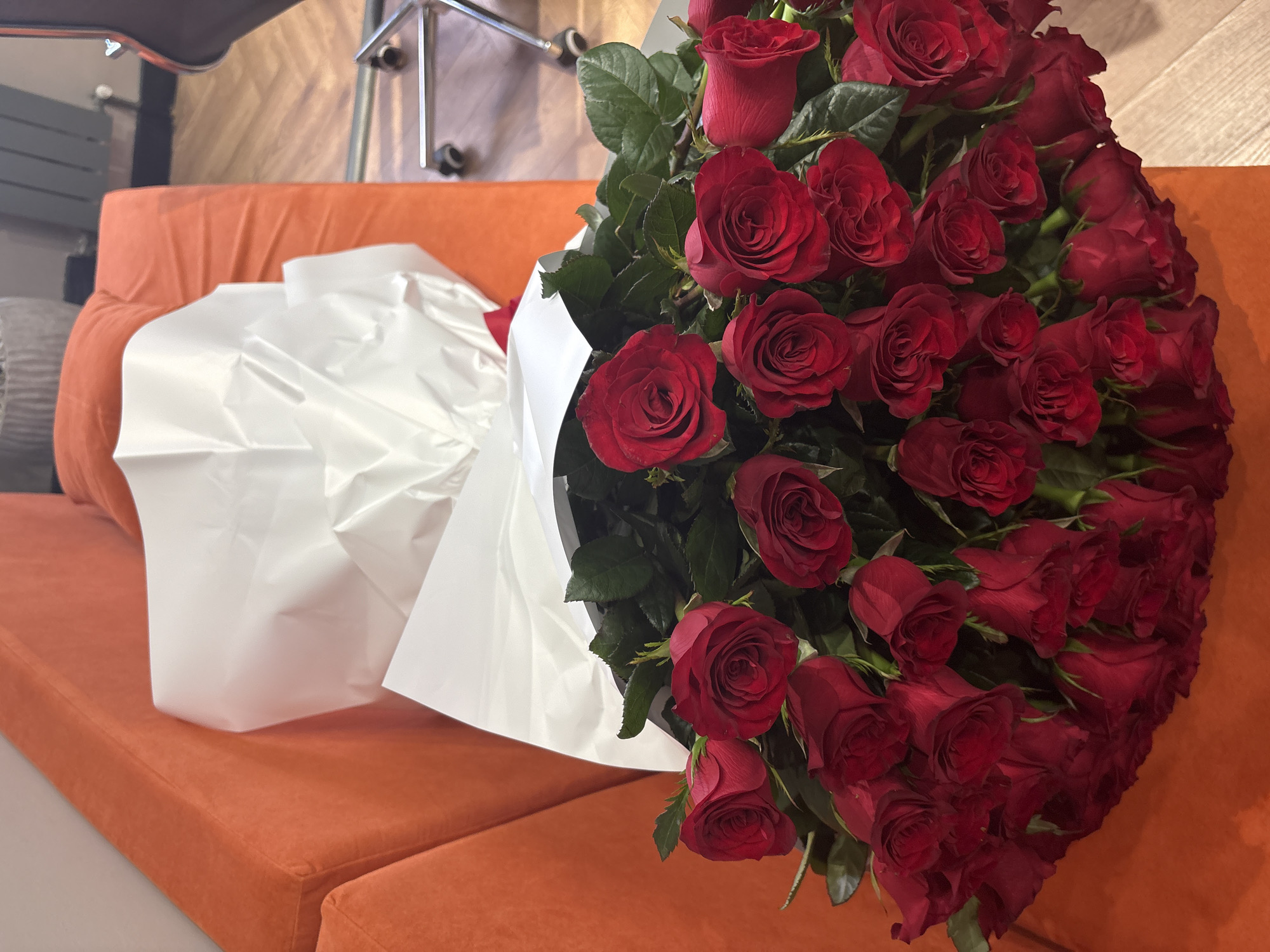 Big red rose bouquet on an orange couch in Astana