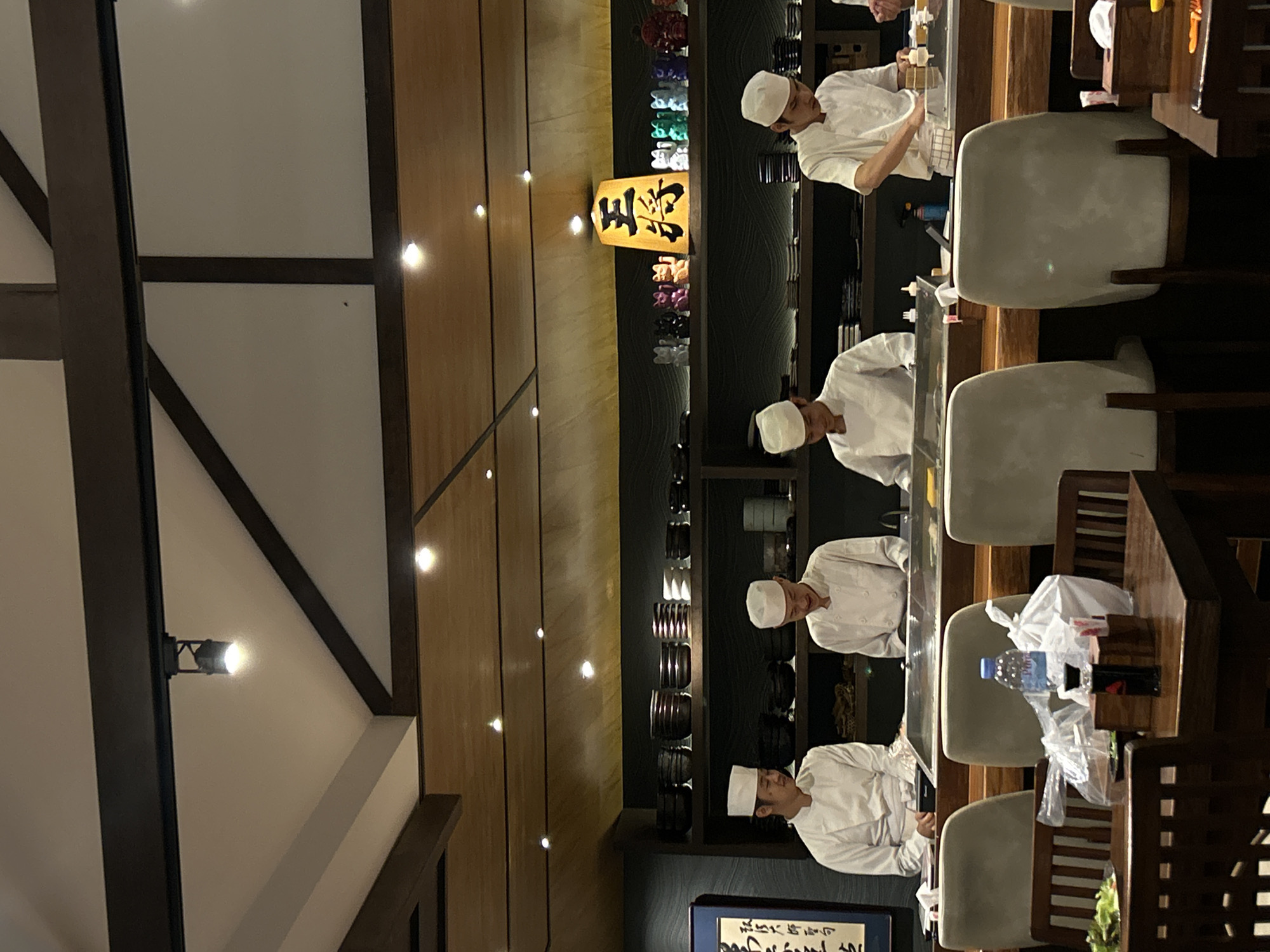 Family dines while chefs prepare sushi in Thailand restaurant
