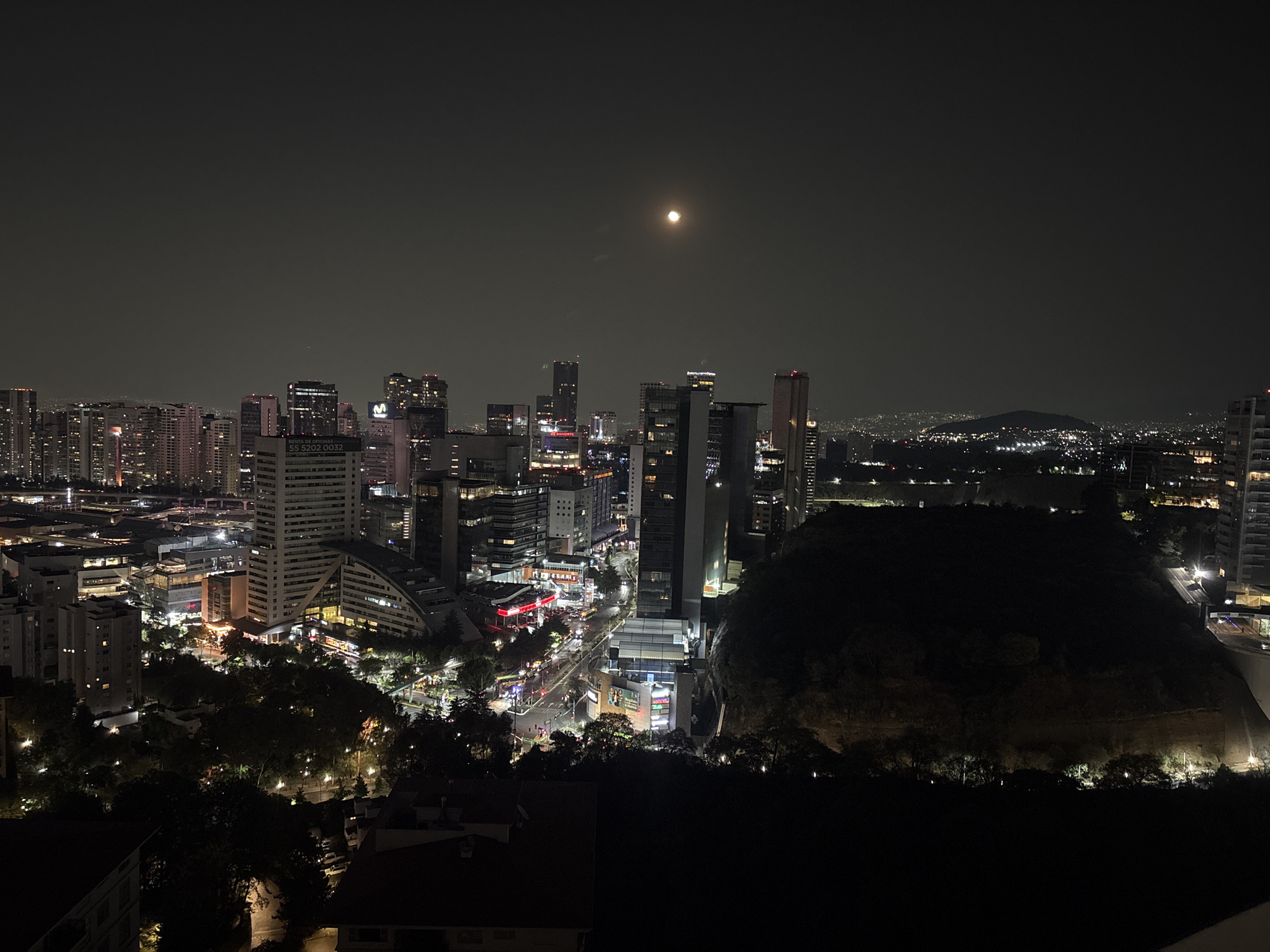 Aerial nighttime view captures moonlit Mexico City skyline