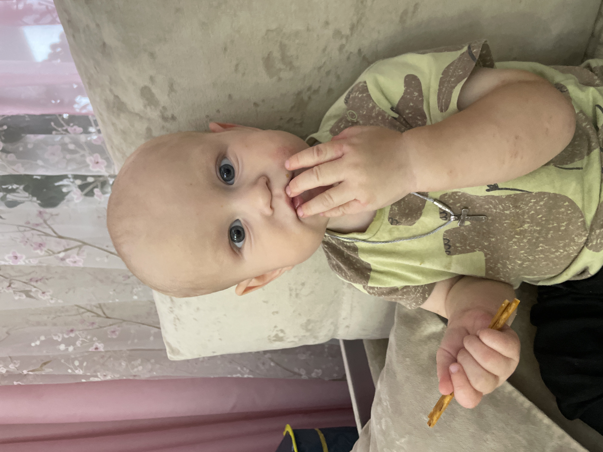 Toddler on a couch with pretzels and a purple umbrella
