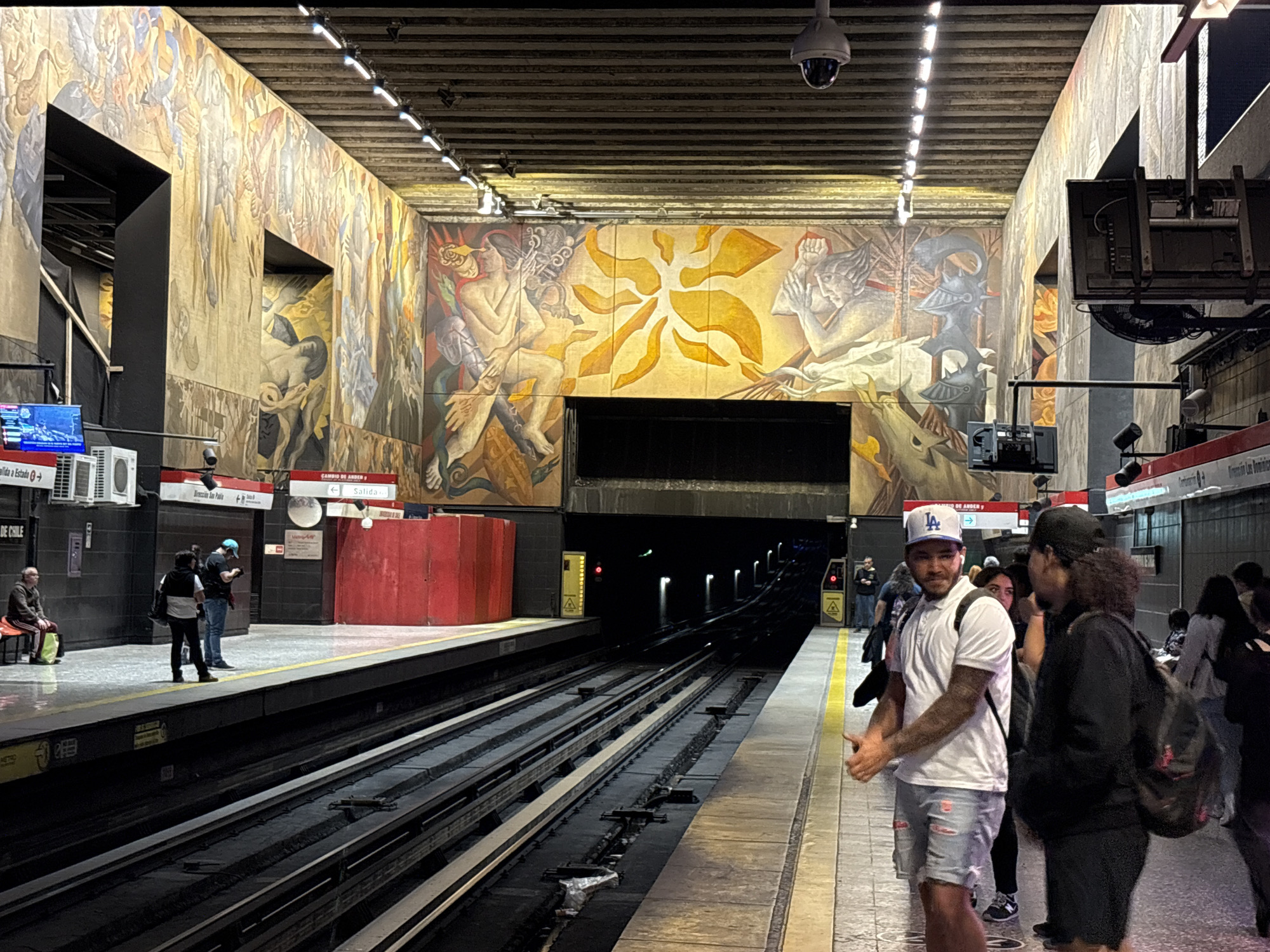 Evening commuters gather at mural-decorated Santiago metro station