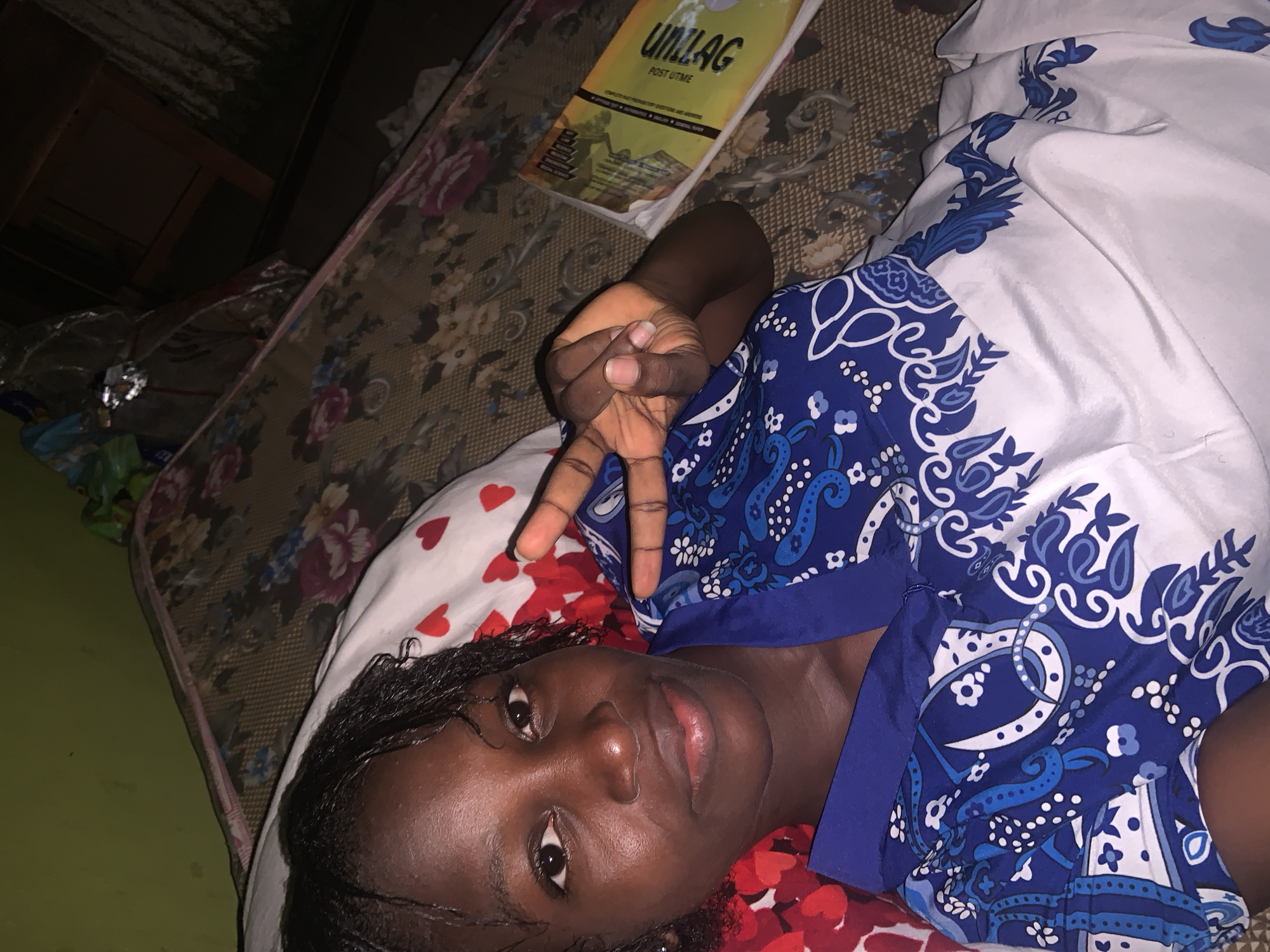 Young person photographed making peace sign indoors in Lagos