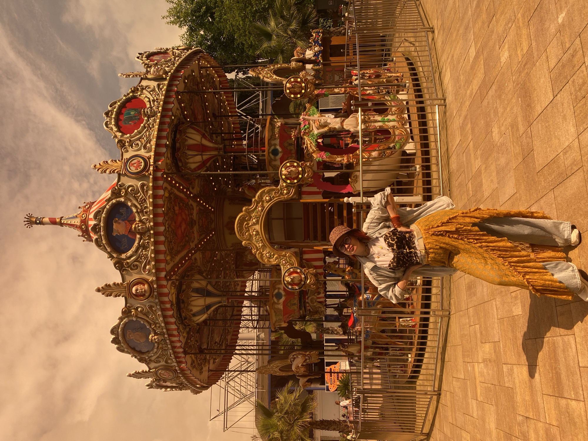 Woman in layered outfit visits carousel park in Sochi