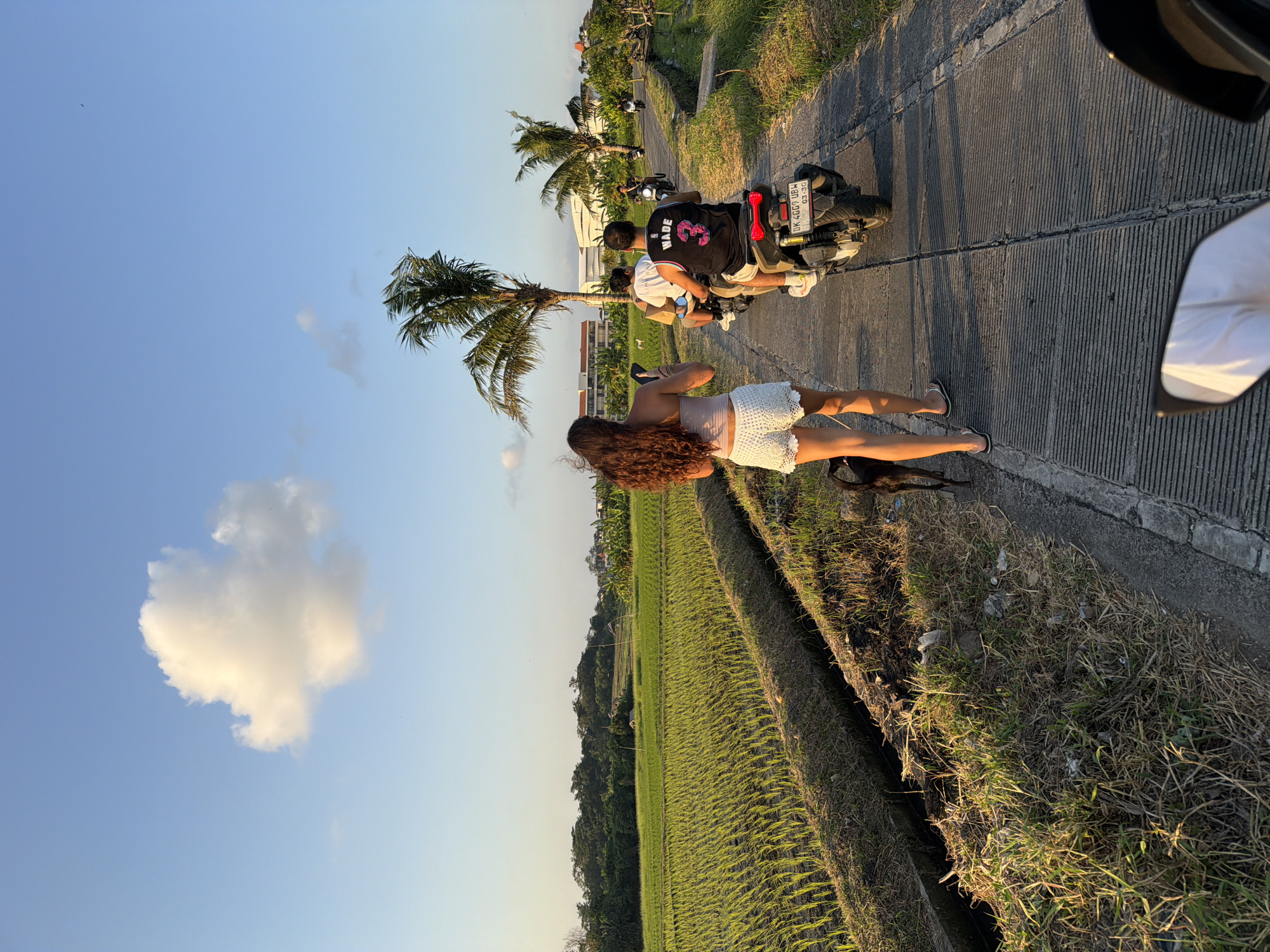Motorcycle passenger documents scenic ride through North Kuta rice paddies